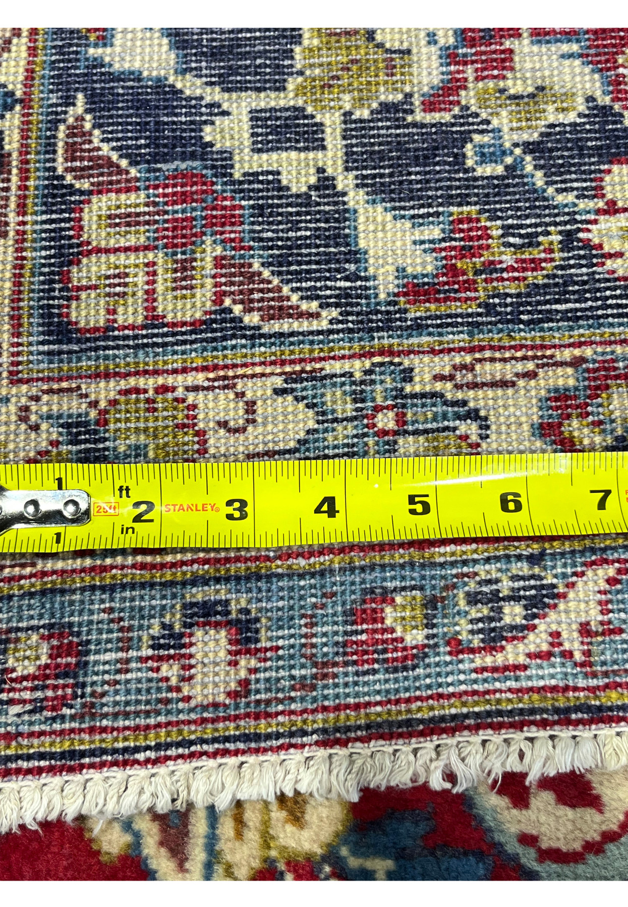 Backside knot density measured on Persian Najafabad, ruler showing tight knot count, 200 to 220 KPSI hand-knotted wool