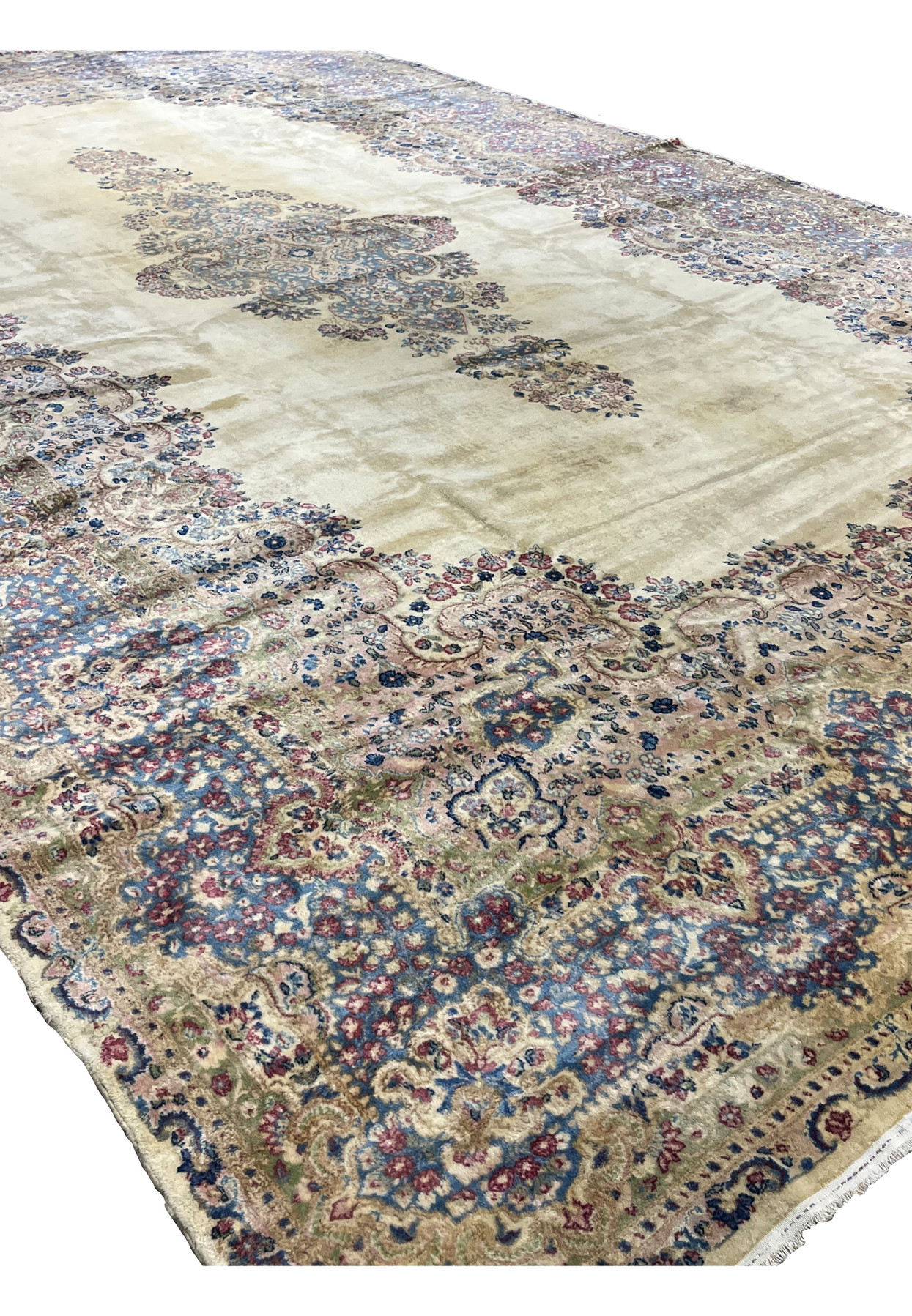 Angled view of 12x19 Persian Kerman, ivory field with floating medallion and pastel floral border, for grand dining room
