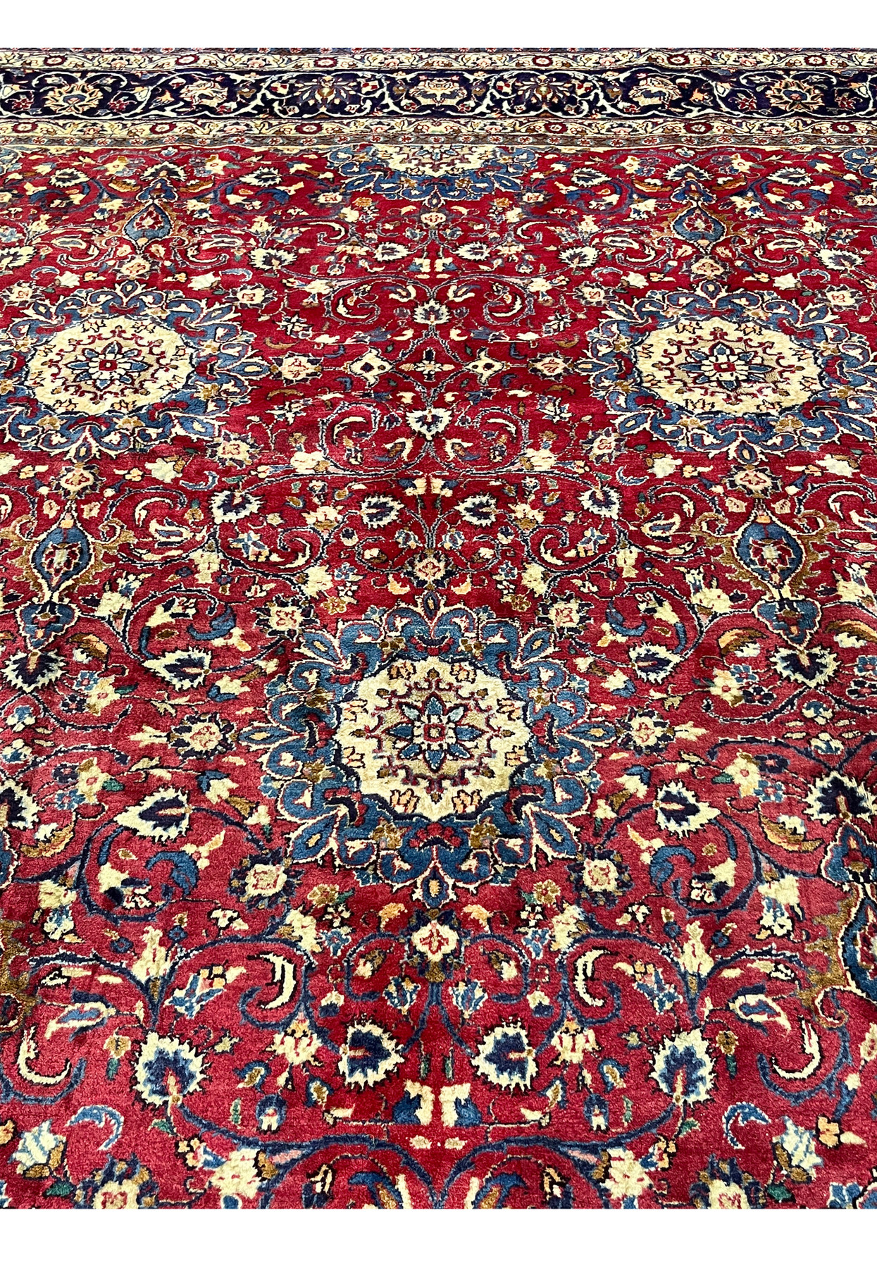 Midfield detail Persian Isfahan rug, ivory rosette discs floating on deep red ground with slate blue scrolling vinework, authentic hand-knotted