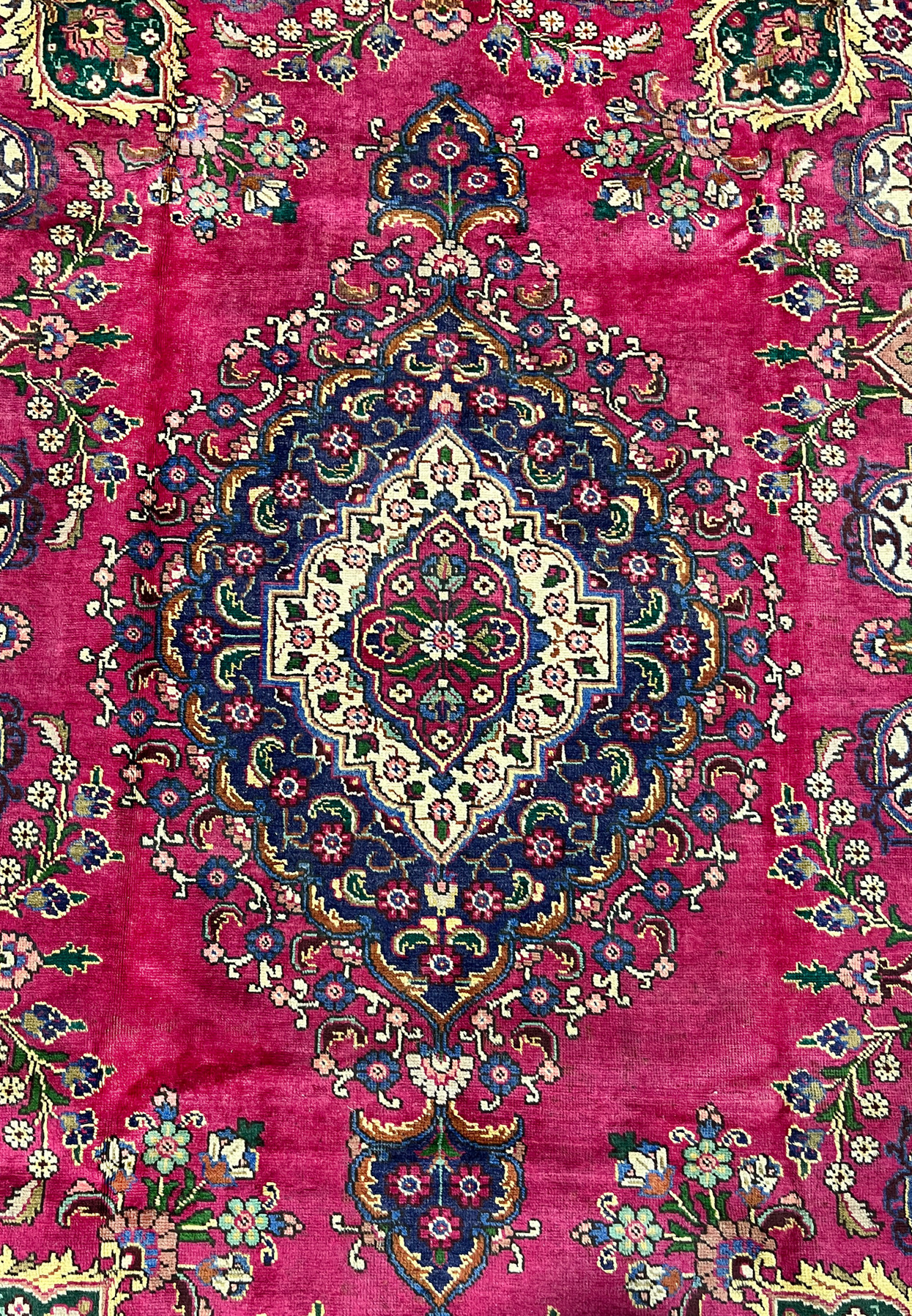 Central medallion of Persian Kerman rug, deep navy diamond with serrated edge and ivory floral cartouche, authentic handmade workshop weave