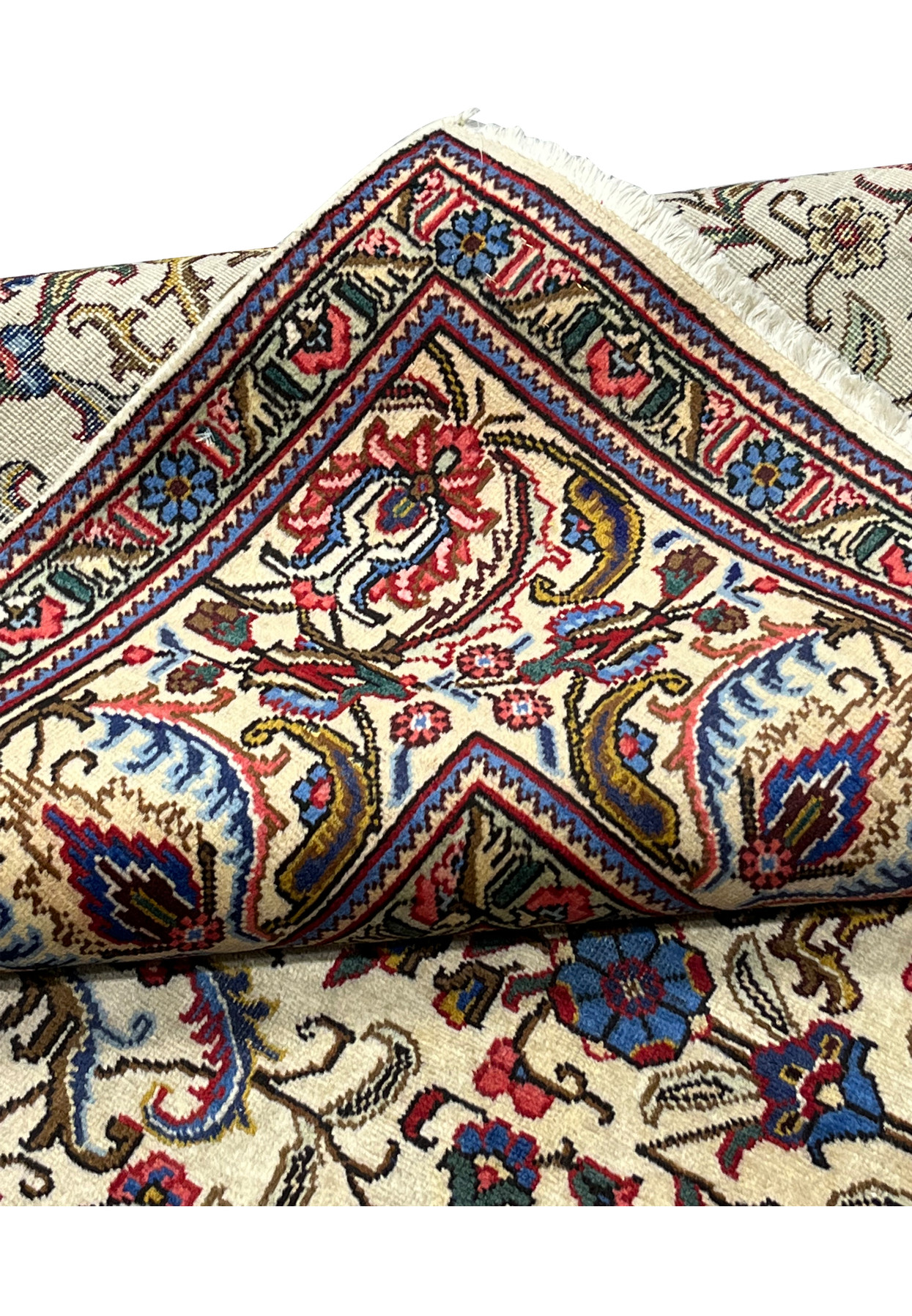 Folded edge of Persian Tabriz rug, fine knotting visible on reverse, authentic handmade wool on cotton for formal traditional interior