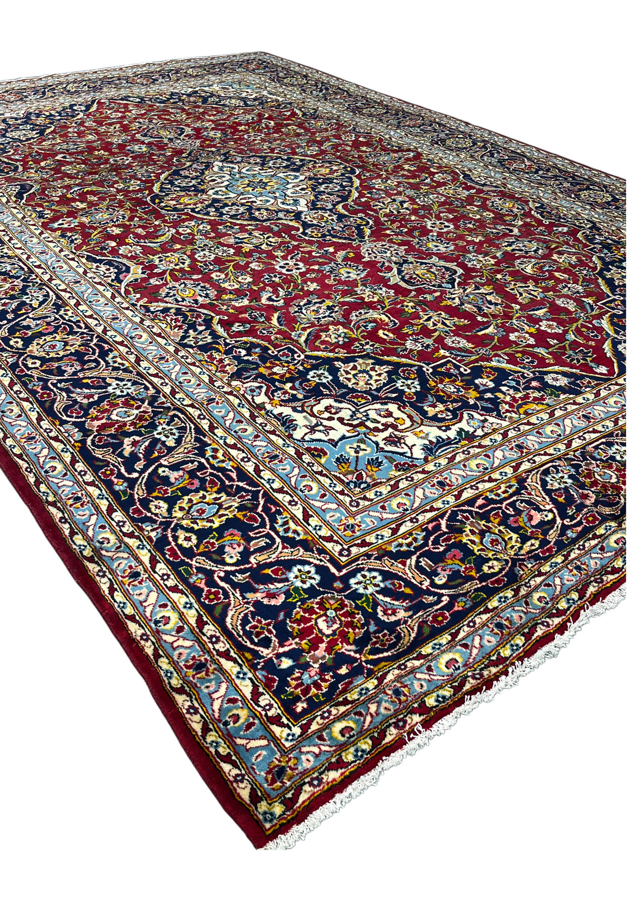 Angled view of 10x15 Persian Kashan rug, red field navy medallion and corners, hand-knotted for large living room
