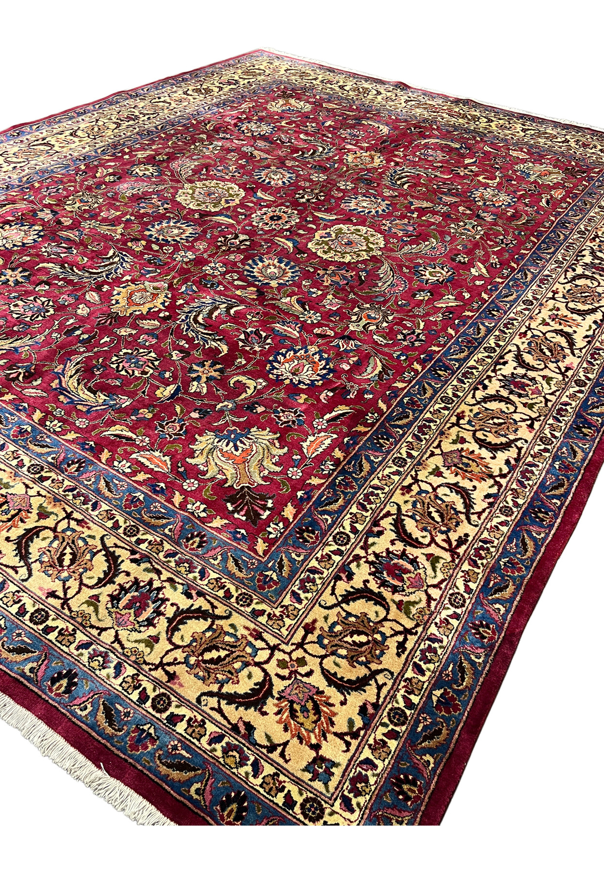 Angled view of 10x13 Persian Mashad rug, signed Shash-Kalani allover floral on red field, hand-knotted for large dining room