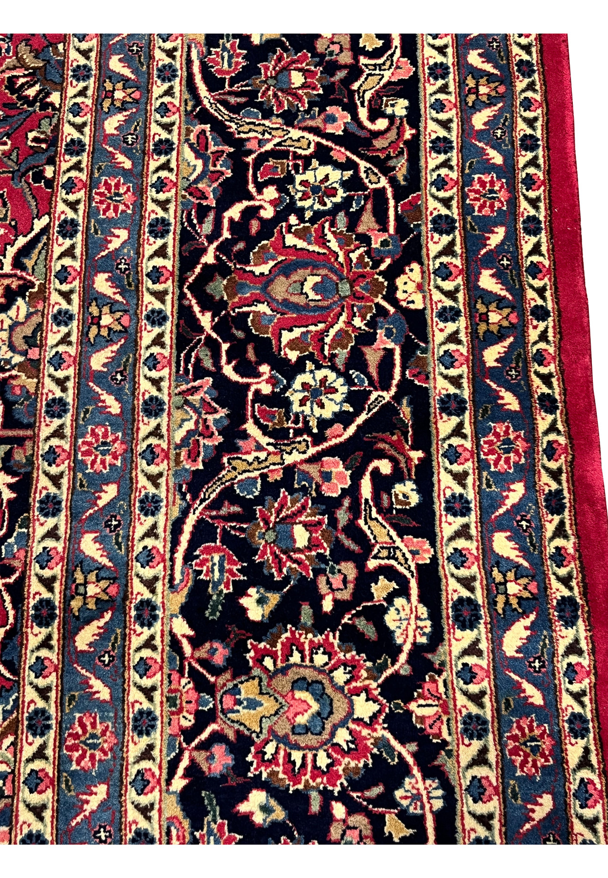 Border close-up of authentic Mashad rug, navy palmette and vine band framed by sky blue and ivory guards