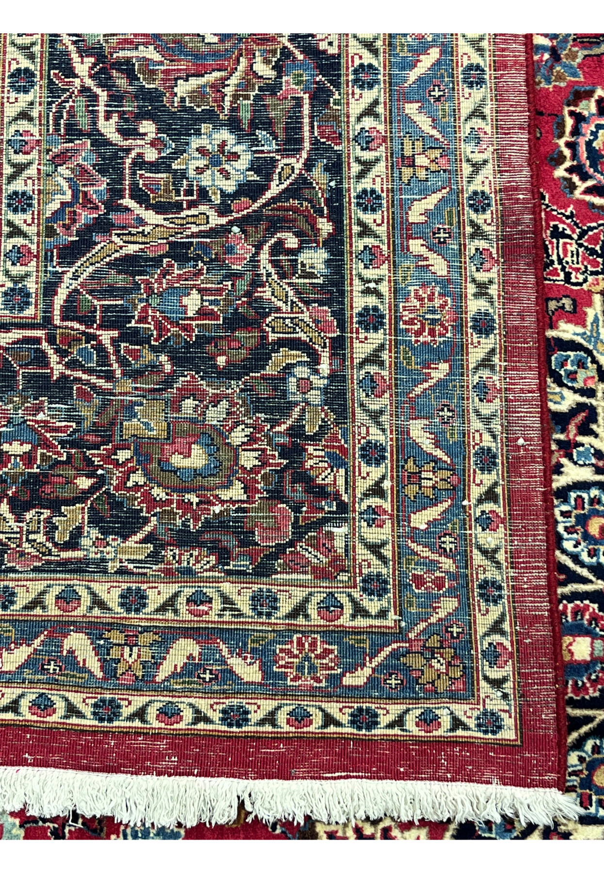Backside corner of Persian Mashad rug, cotton foundation with even hand knotting and red selvedge