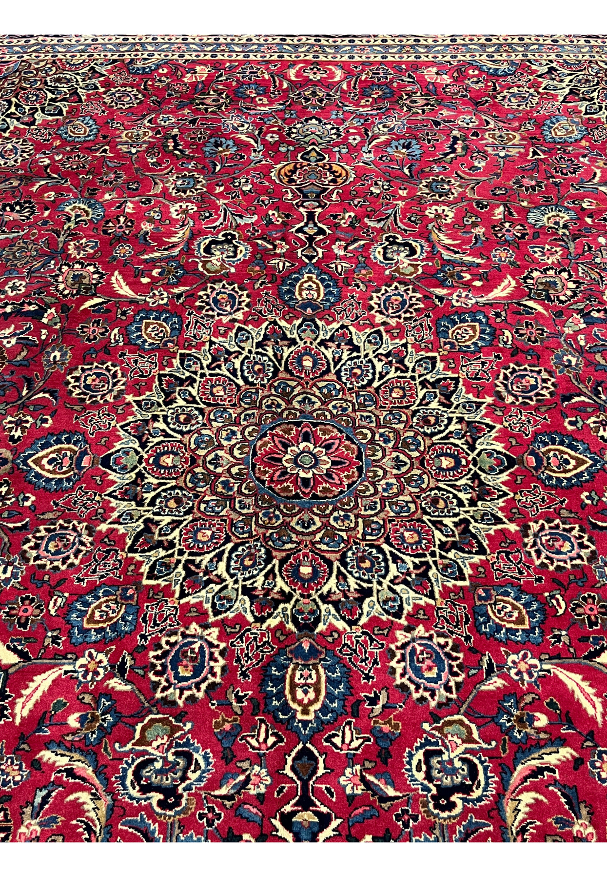 Central medallion detail of vintage Persian Mashad rug, navy and ivory rosette medallion on cherry red field