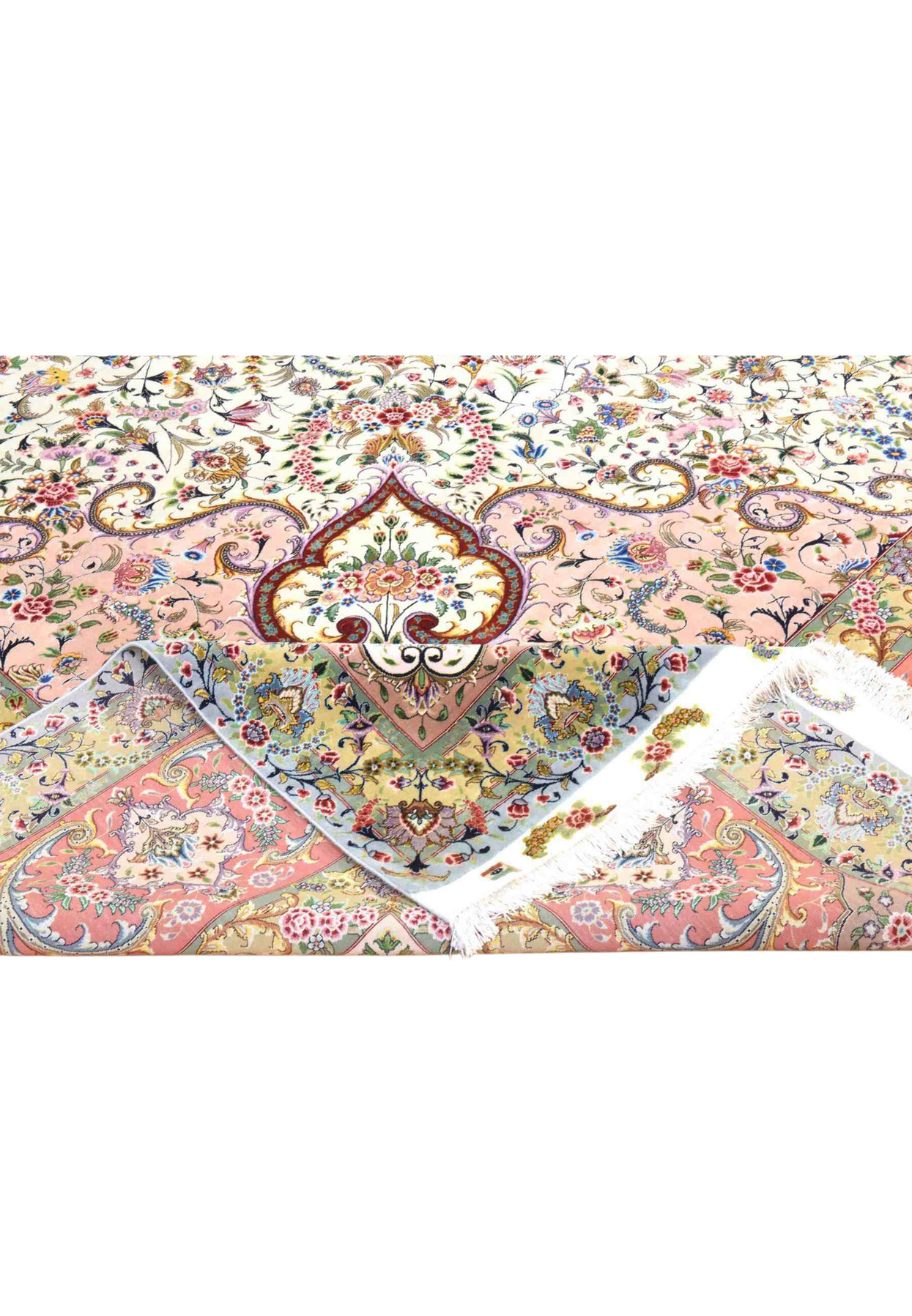Folded corner of wool and silk Tabriz rug revealing the intricate floral border and ivory selvage