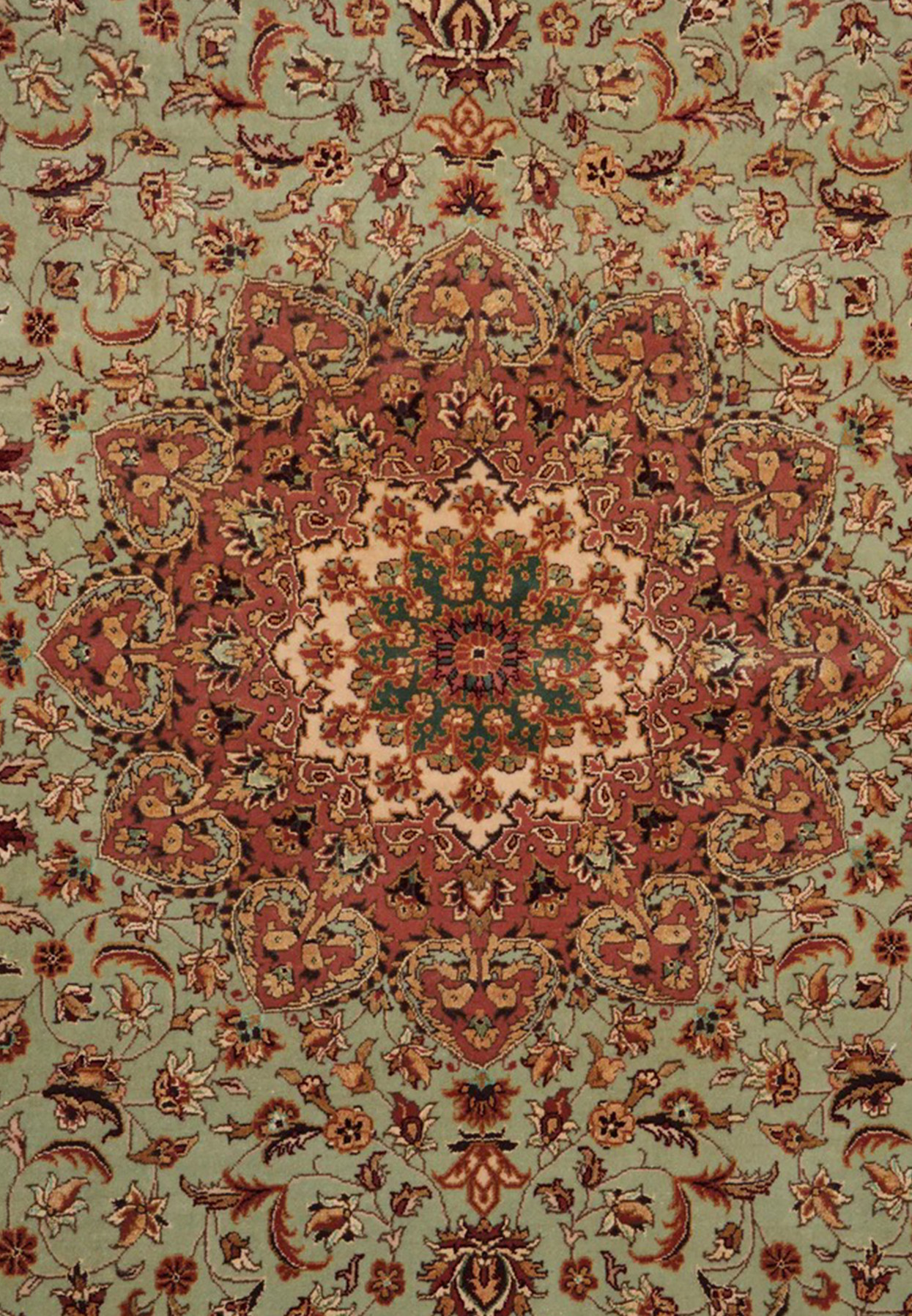 Center star medallion of Persian Isfahan rug, rose and ivory on a sage-green field