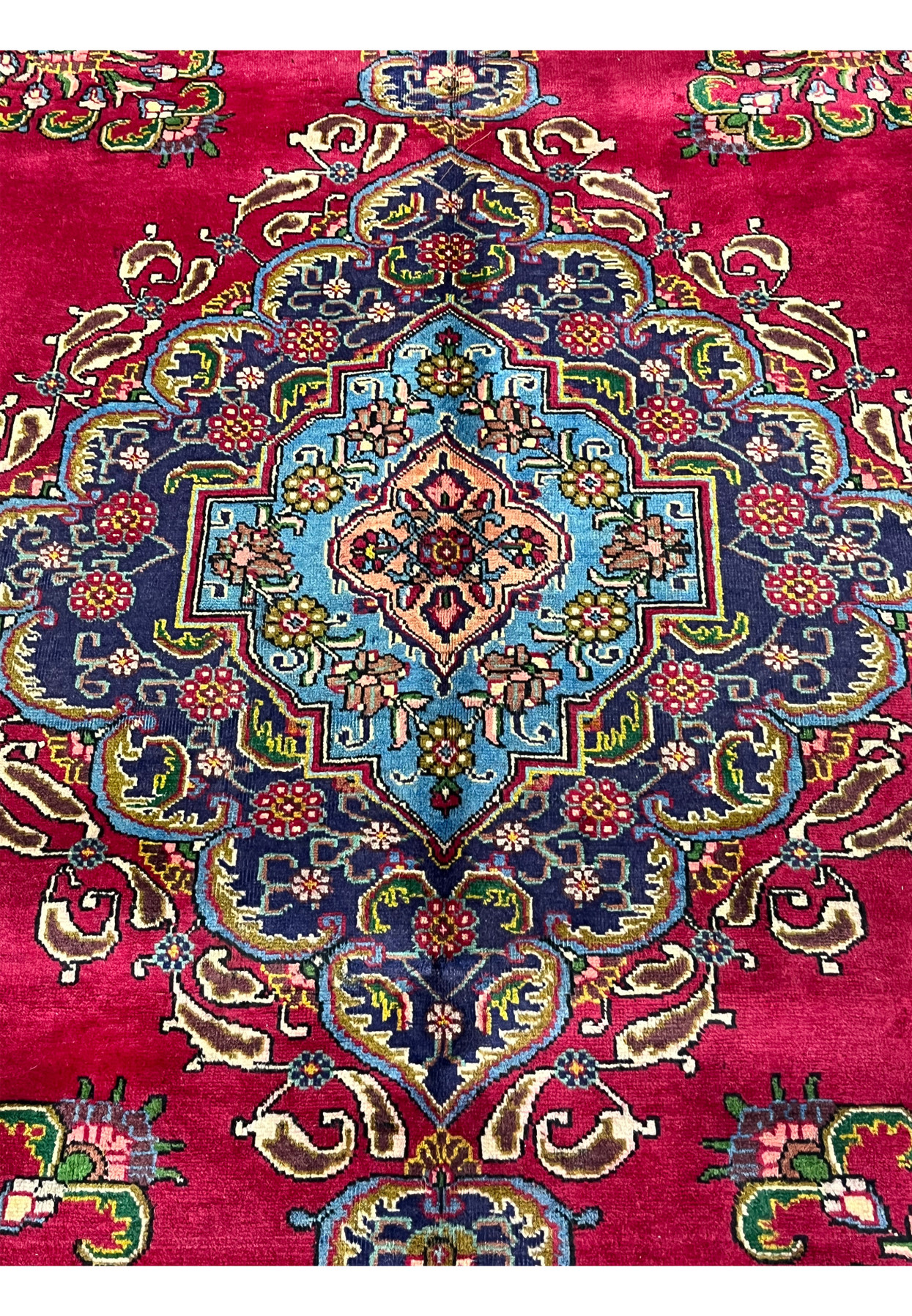 Close detail of Tabriz medallion showing finely drawn floral palmettes, navy ground with sky blue and salmon