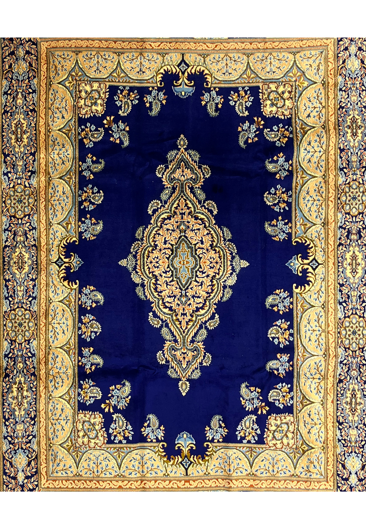 Tight closeup of central field of Persian Yazd rug, peach and gold floral medallion on midnight navy with scattered boteh