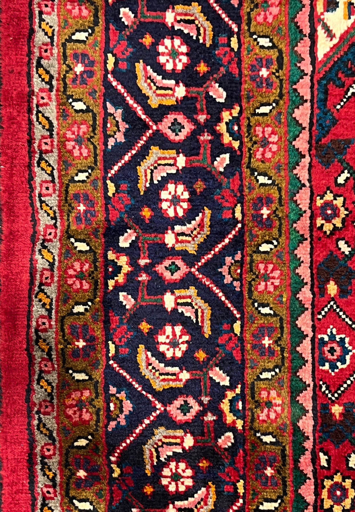 Navy main border in close detail showing turtle palmettes and rosettes in pink, saffron and cream