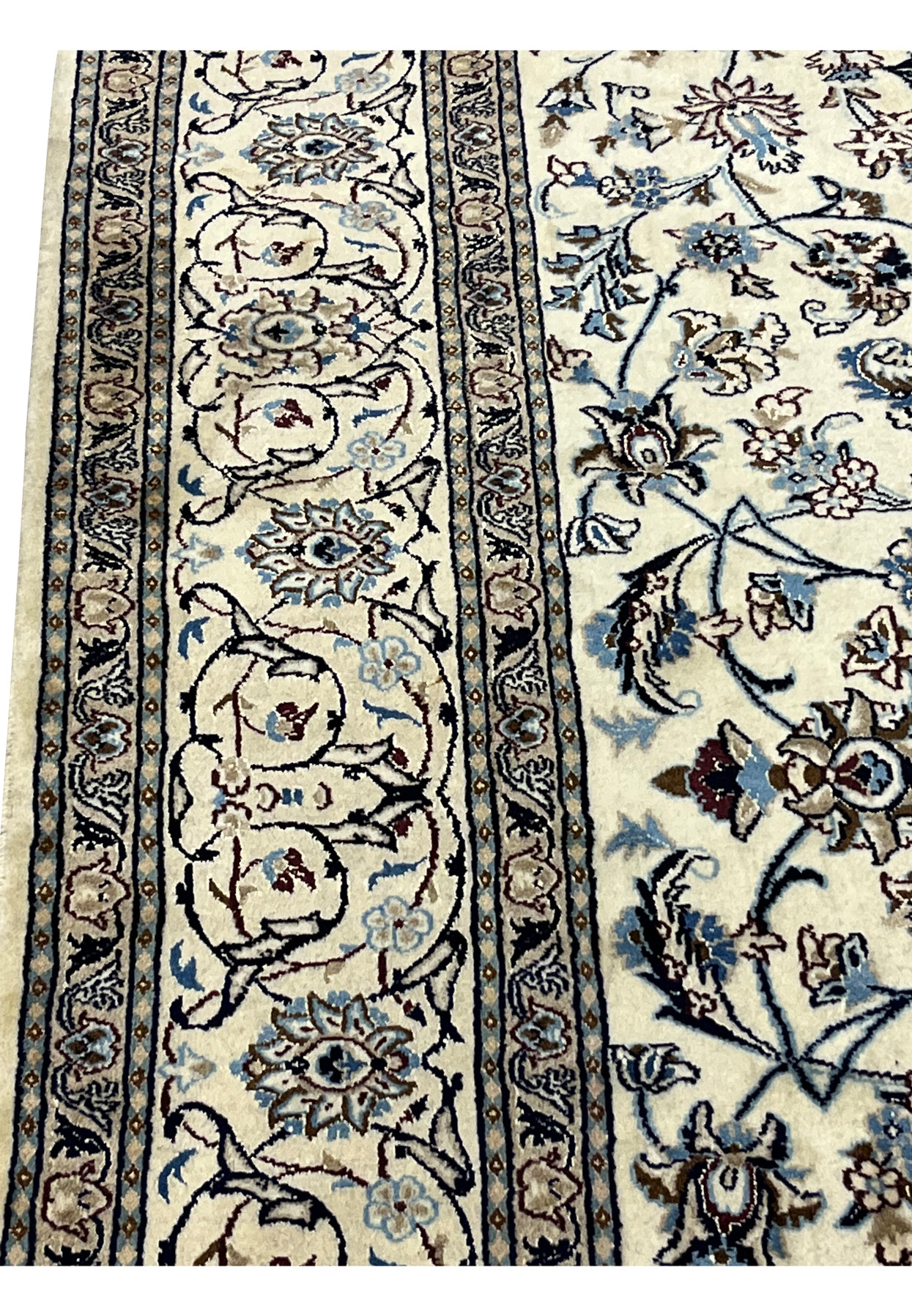 Wide ivory border in detail showing palmette scrollwork and uneven color variation in the wool