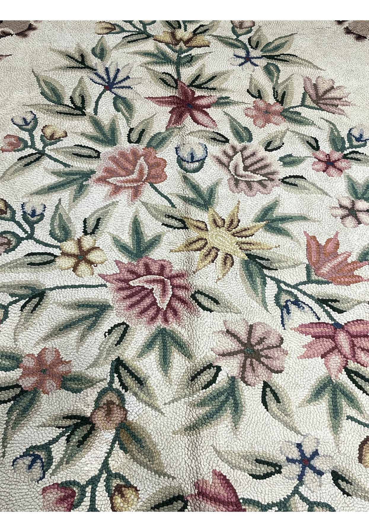 Close view of the cream center filled with naturalistic roses, daisies and star flowers in soft tones