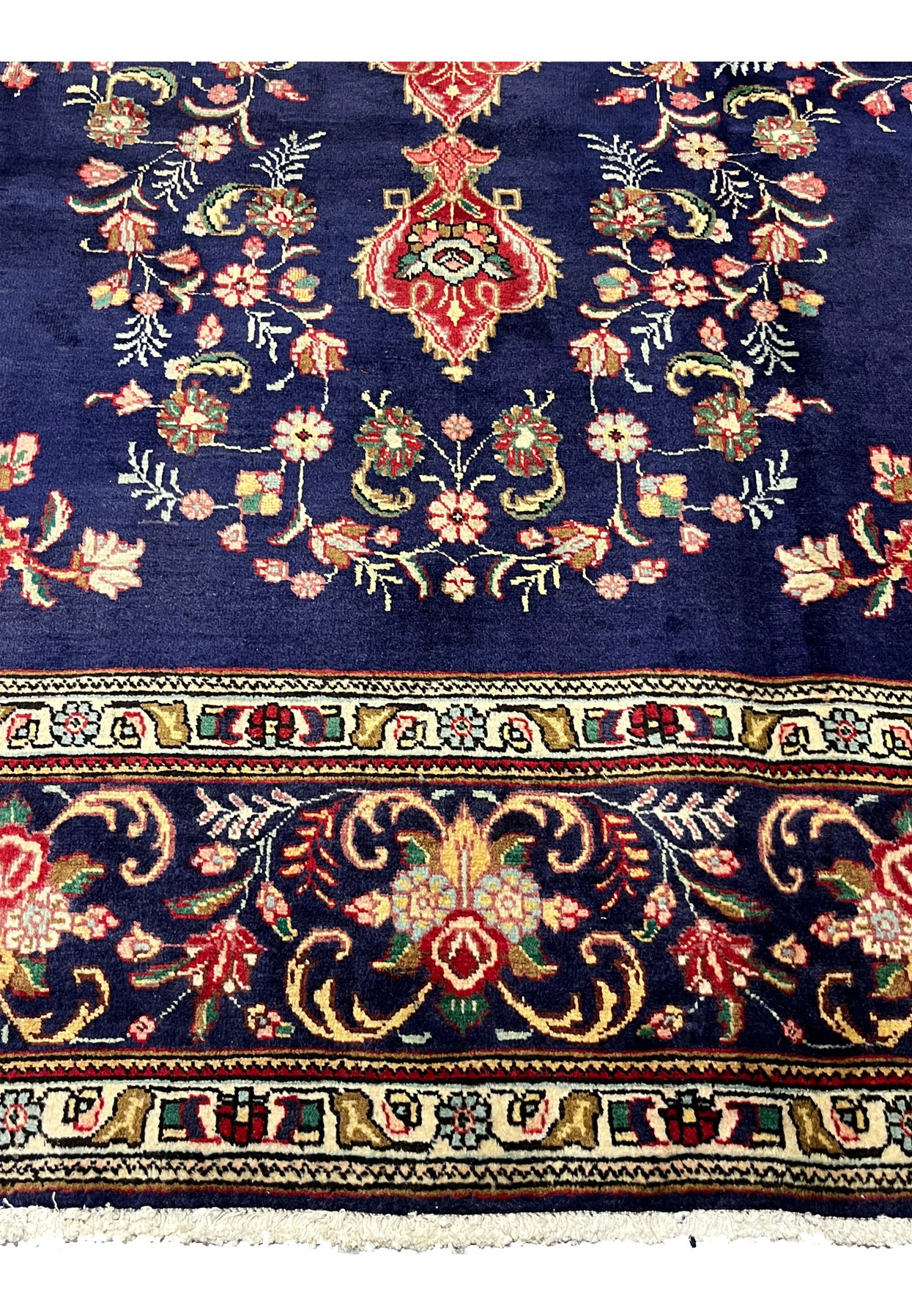 Lower border of the Tabriz rug with a navy rose palmette vine and ivory floral guard stripes