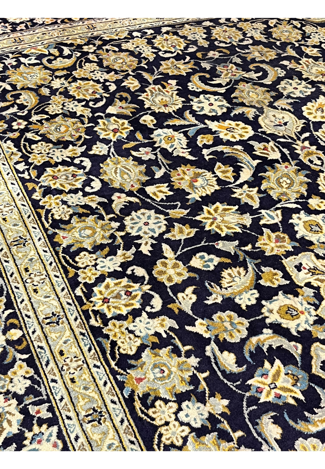 Detailed look at the densely knotted floral drawing in antique gold powder blue and ivory