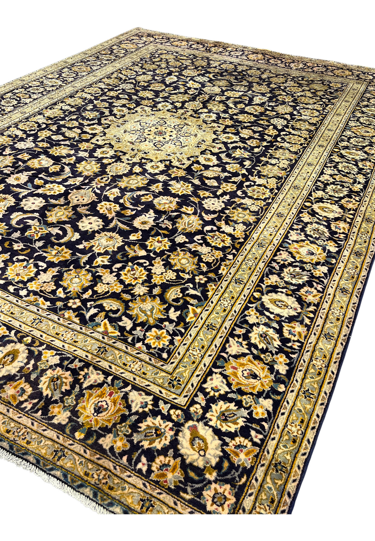 Angled view of the 8x12 signed Kashan showing lustrous navy wool and layered gold borders