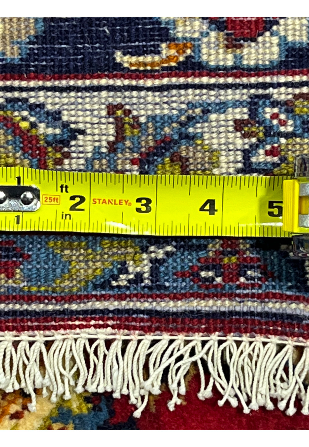 Backside with tape measure across the fine 180 to 200 KPSI hand-tied knots