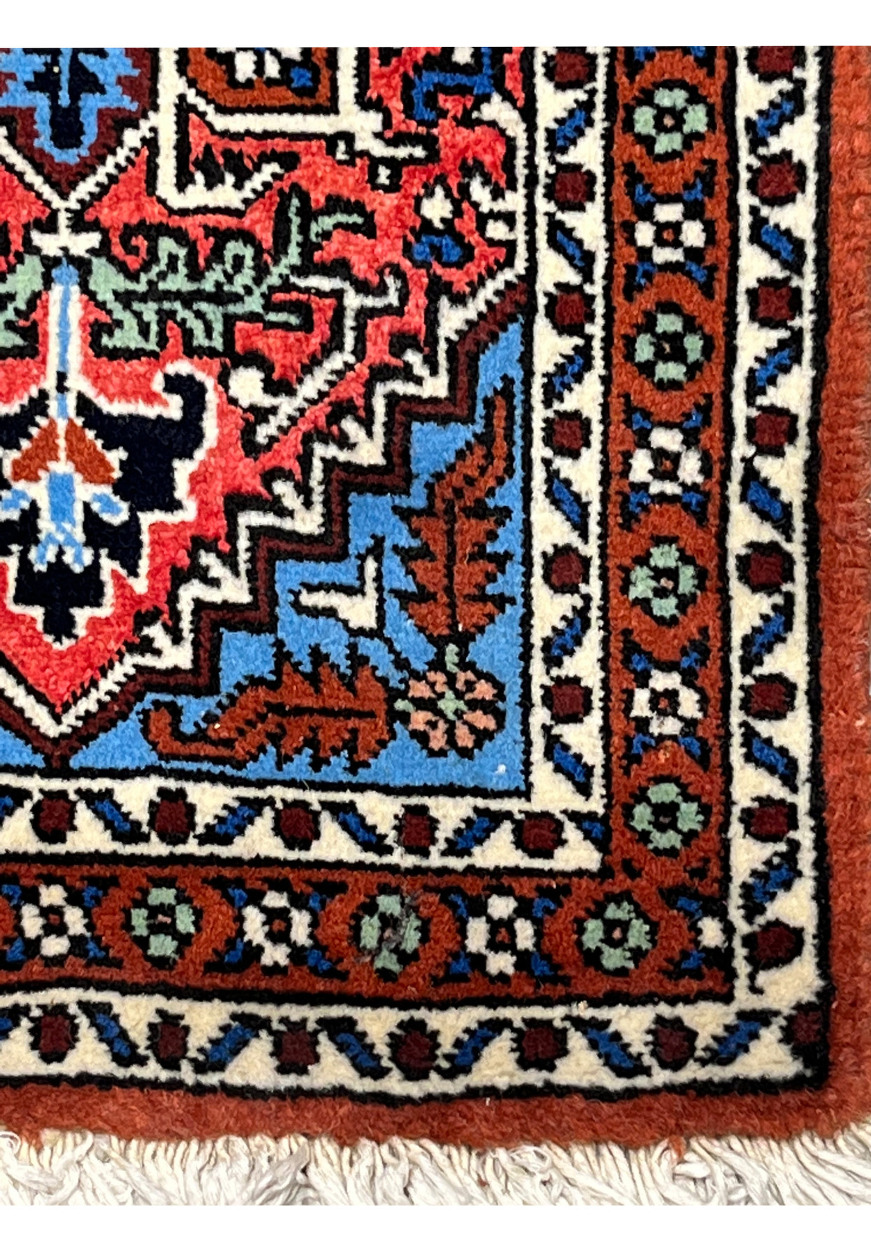 Corner of the small Ardebil rug showing rust border with green rosettes and sky blue spandrel