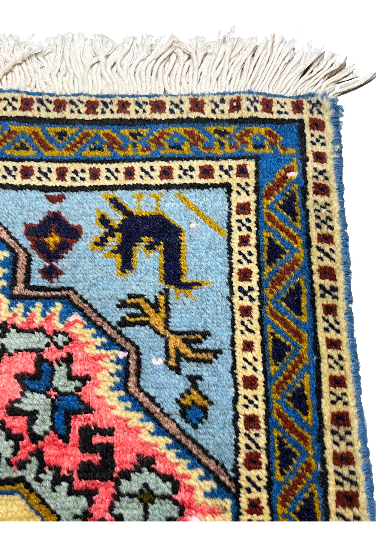 Inner guard borders in ivory and blue framing the powder blue field with stylized tribal bird and animal figures
