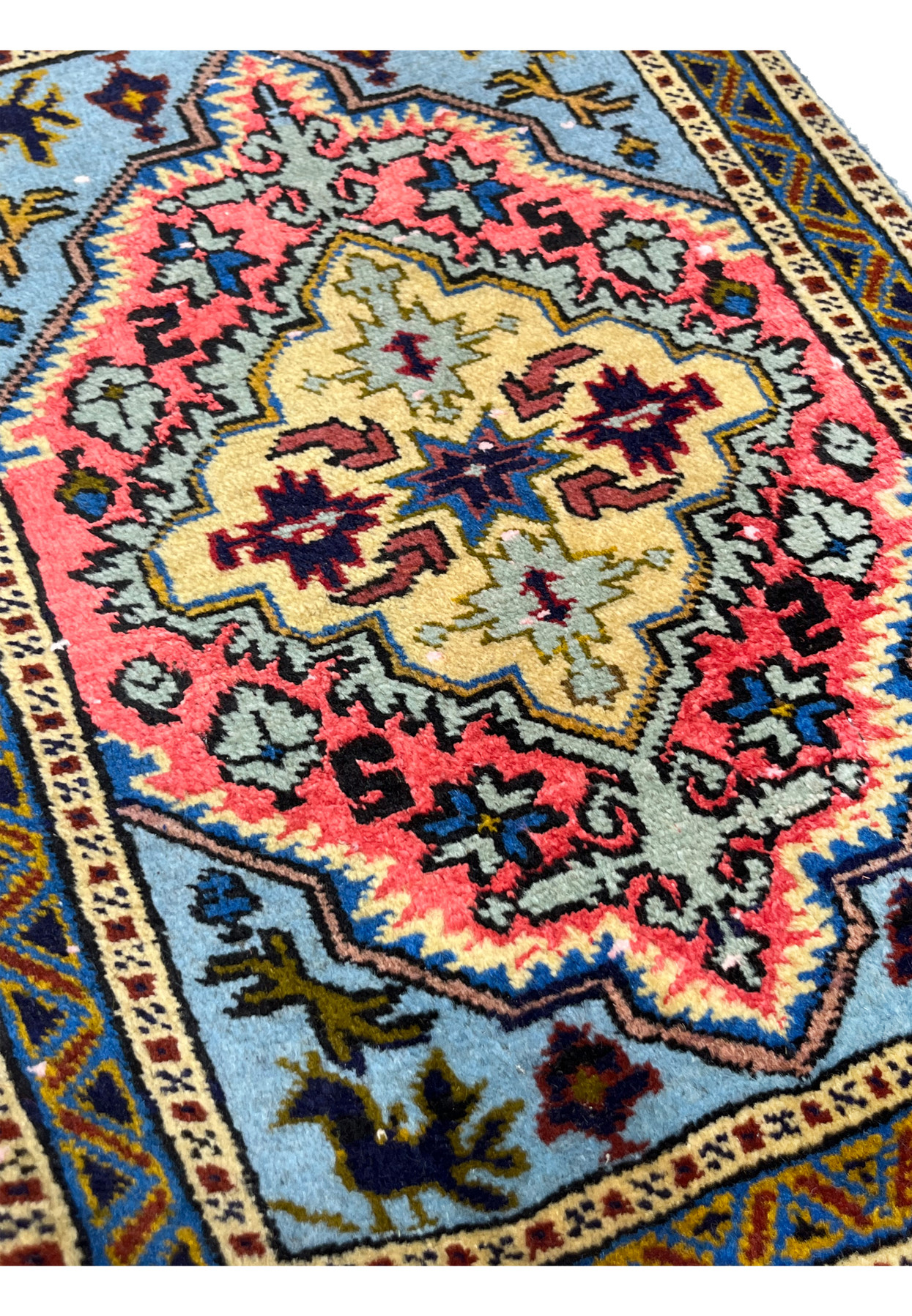 1'3" x 2' Persian Ardebil rug at an angle, plush pile catching light across coral and gold medallion