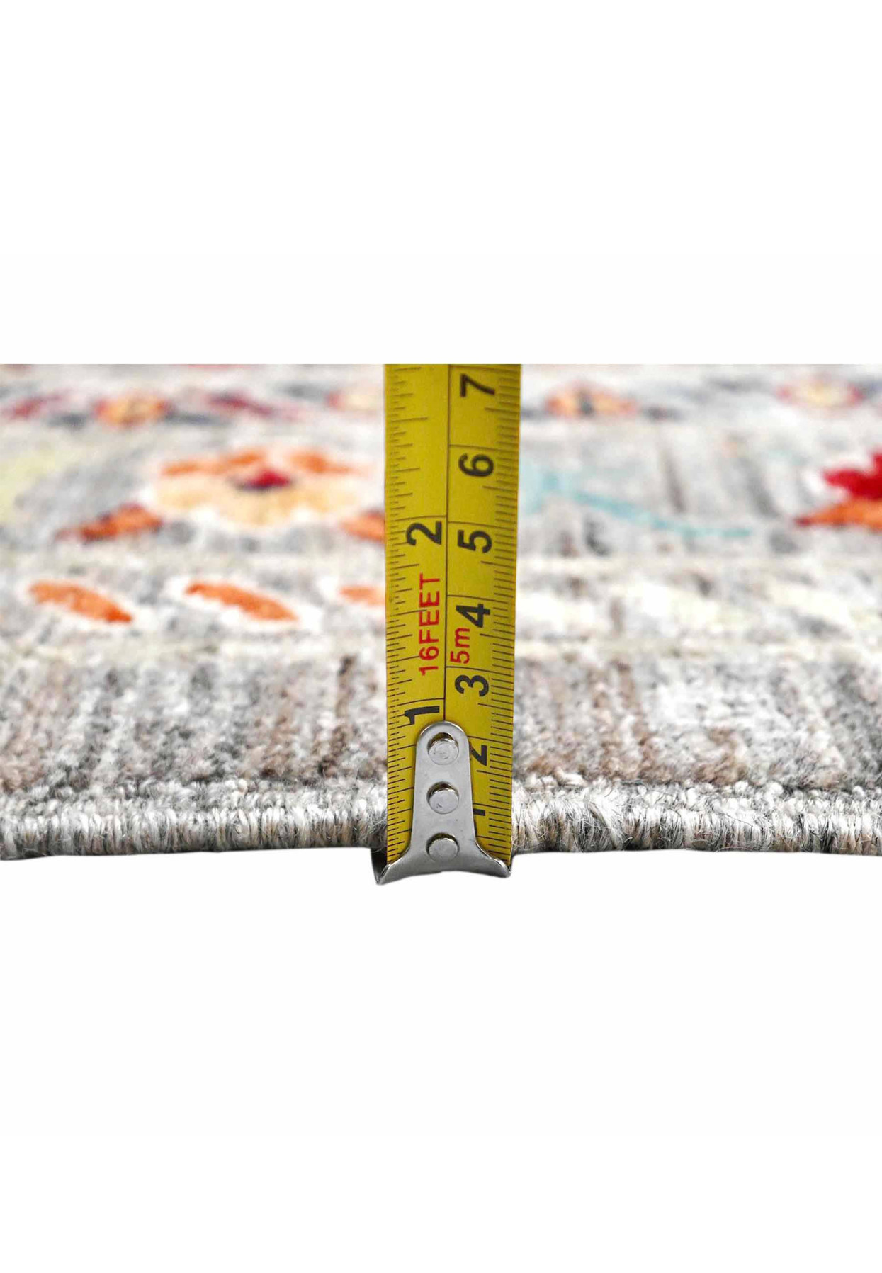 Tape measure showing the deep plush wool pile height of this brand new Afghan Sultani rug