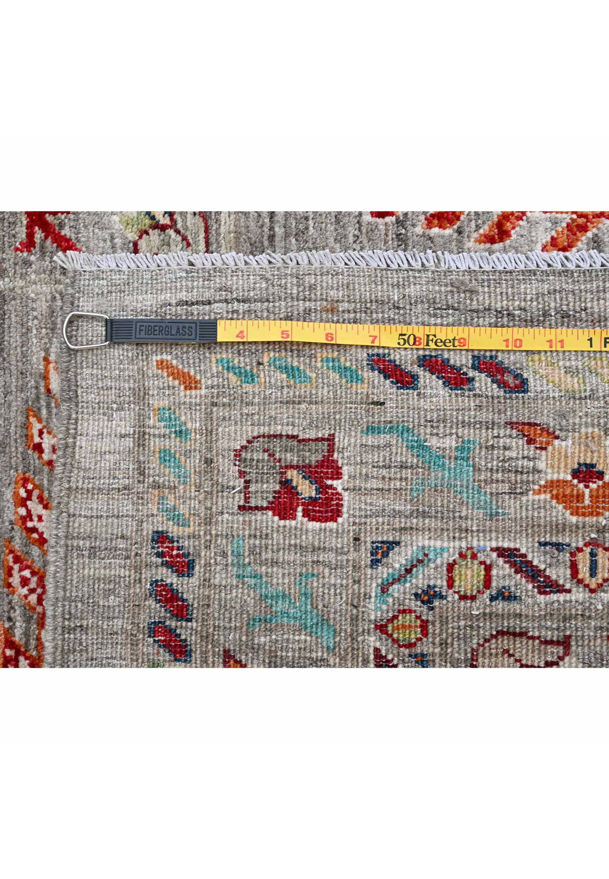Backside knot count meassured with tape, showing 180 to 200 KPSI hand-knotted density on cotton foundation
