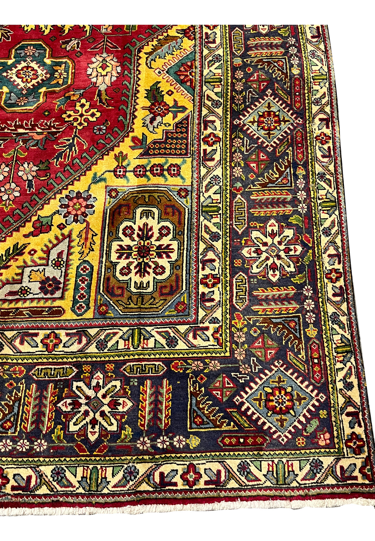Indigo main border of the Tabriz with ivory rosettes, boteh, and serrated diamond motifs in jewel tones