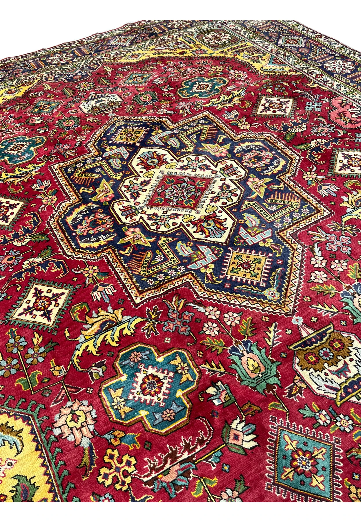 Central ivory and navy medallion of the Tabriz with a red floral diamond core and stepped outline