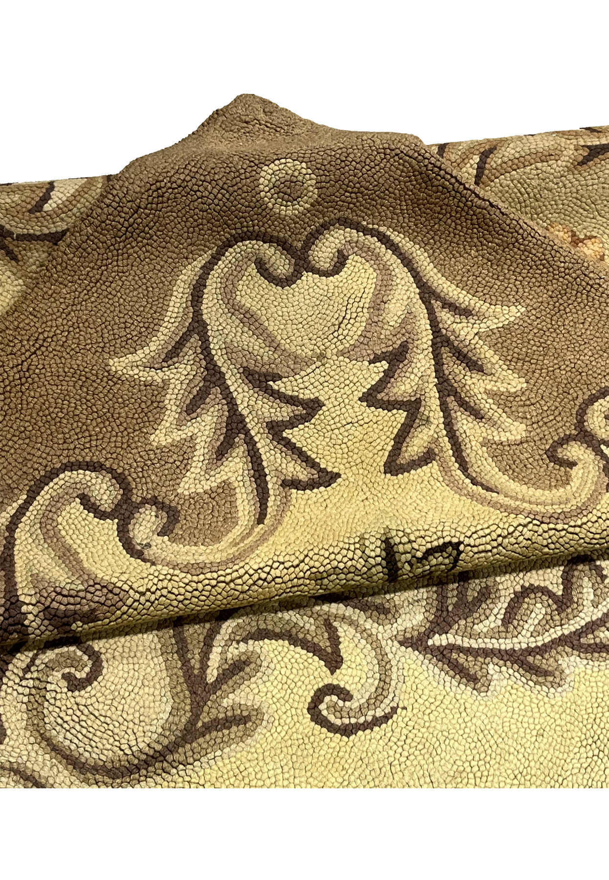 Folded corner of the hooked rug revealing the plush wool loop pile and curling leaf border motifs
