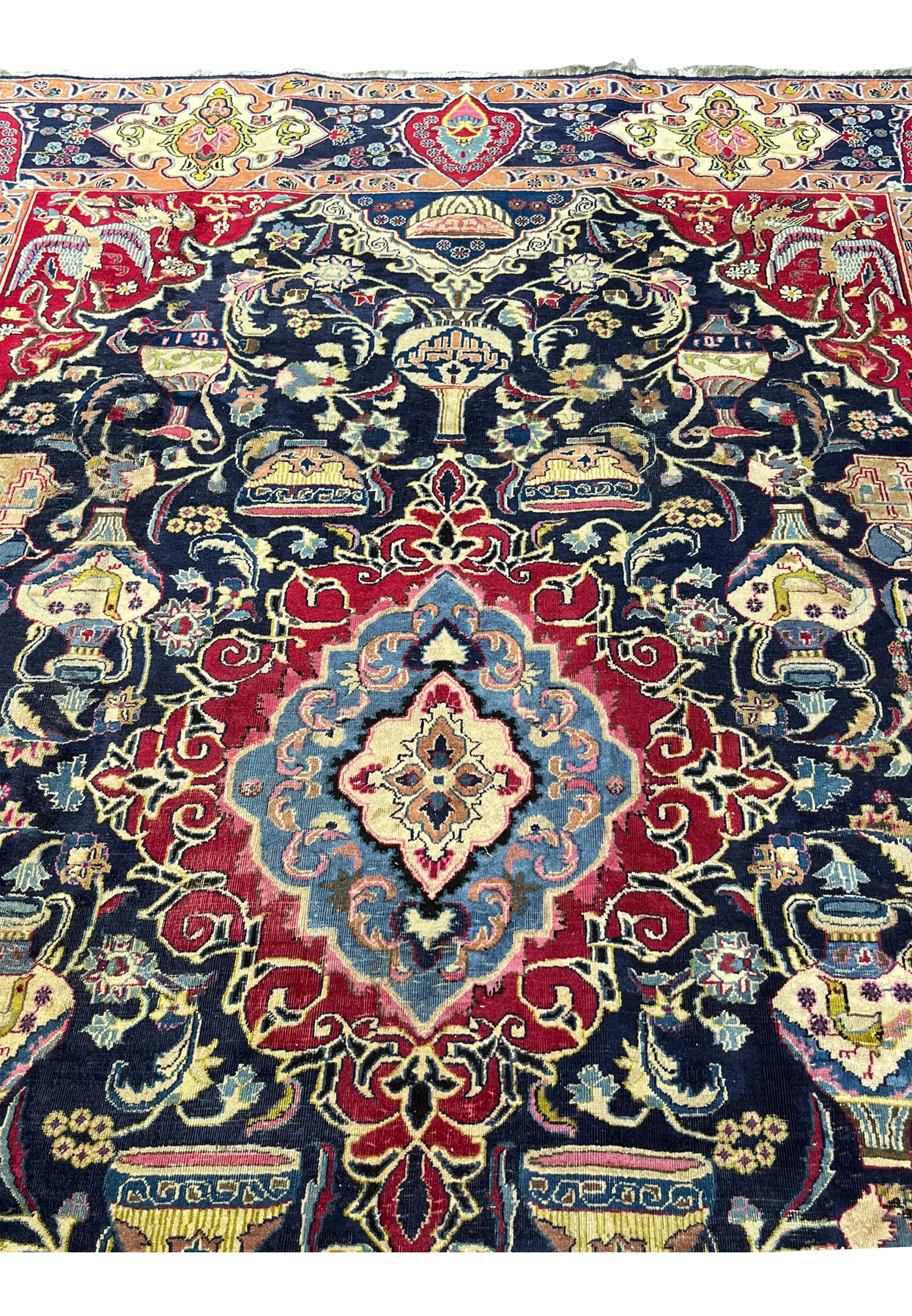 Navy field detail of the Zirkhaki rug with footed bowls, urns, and ancient Persian motifs
