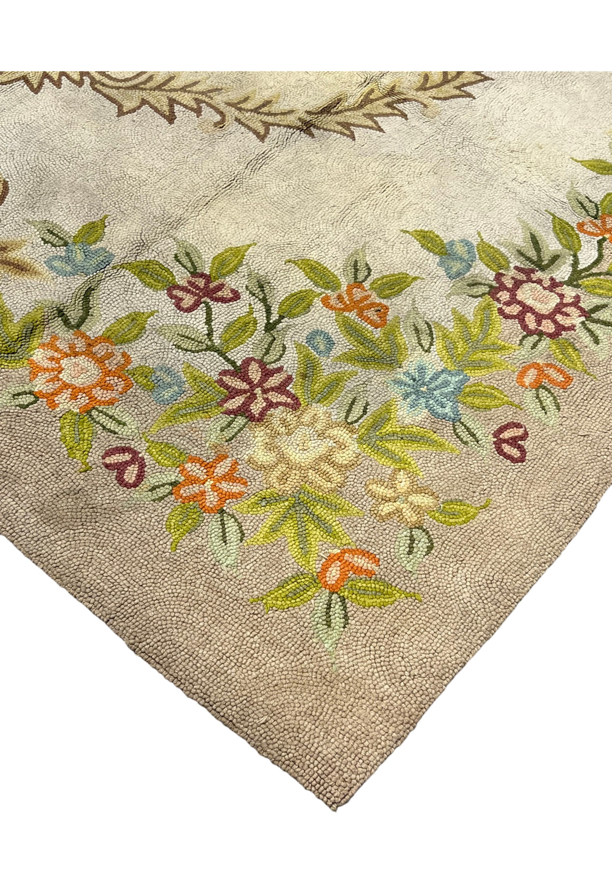 Floral garland border in pastel blooms framing the cream corner of this authentic handmade hooked rug