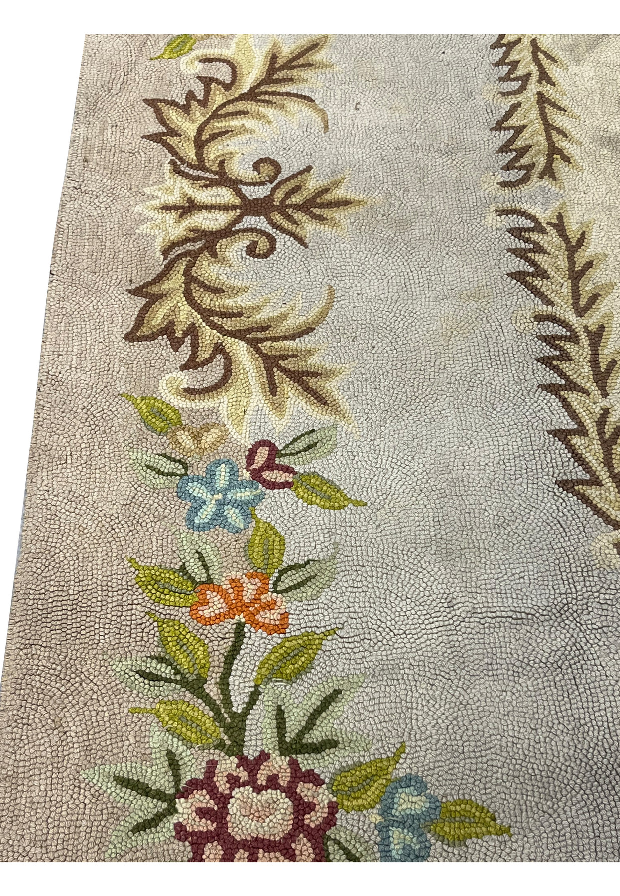 Scrolling acanthus leaf corner and delicate floral spray showing the fine hand hooked wool craftsmanship