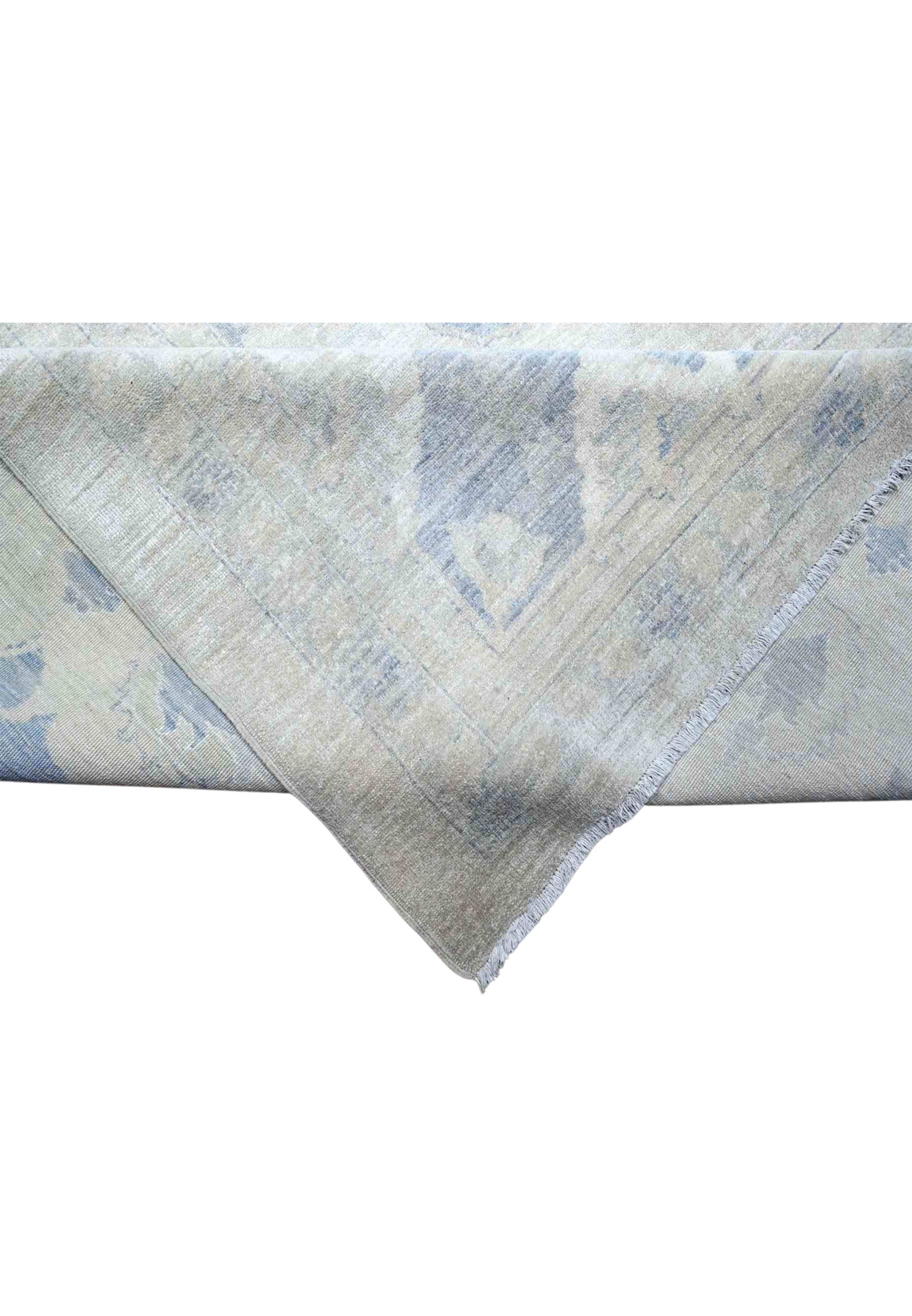 Folded corner of the washed Peshawar revealing the cotton foundation and pale woven selvage