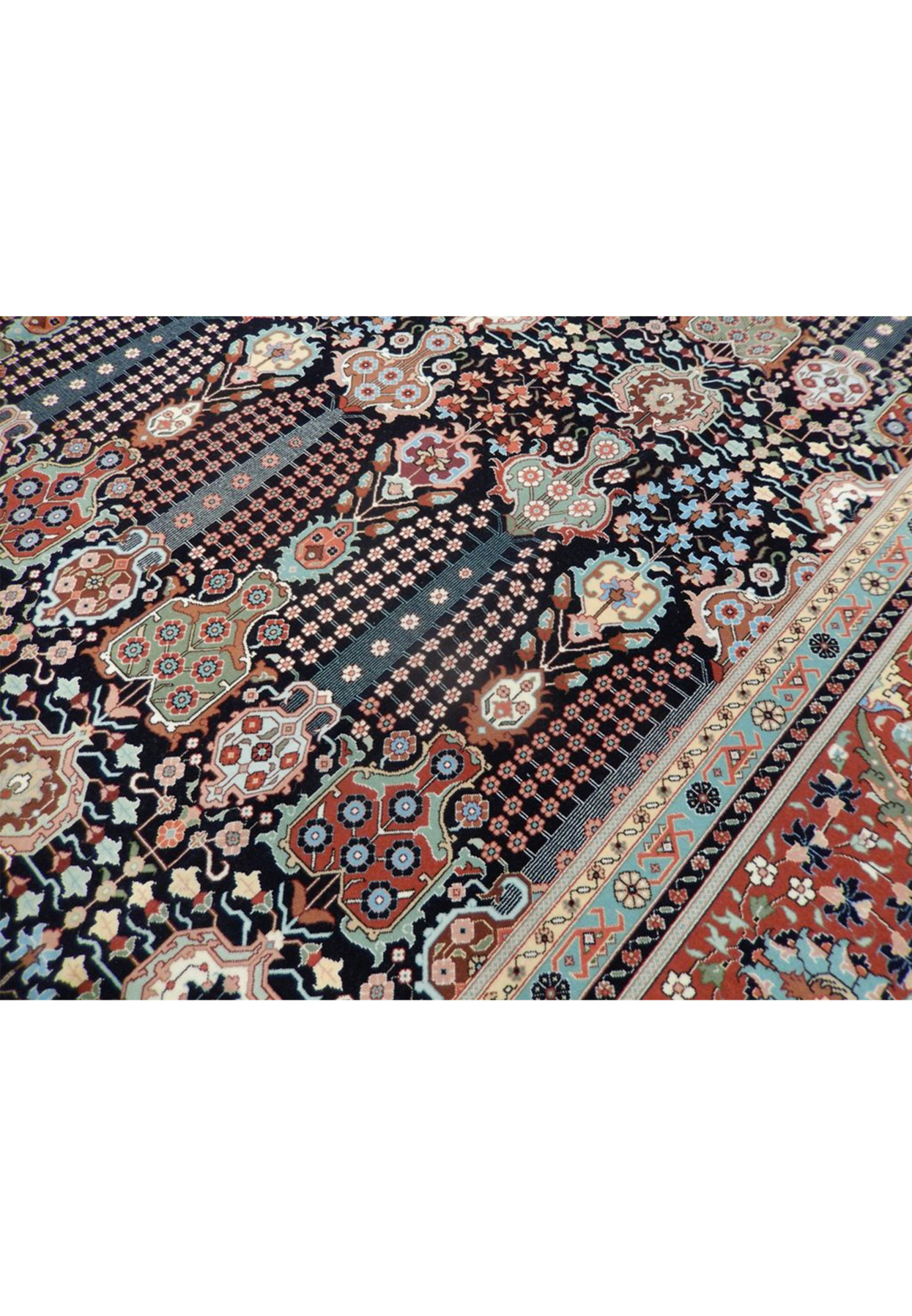 Detail of slender flowering vases and dense blossoms on navy, fine wool and silk Tabriz weave