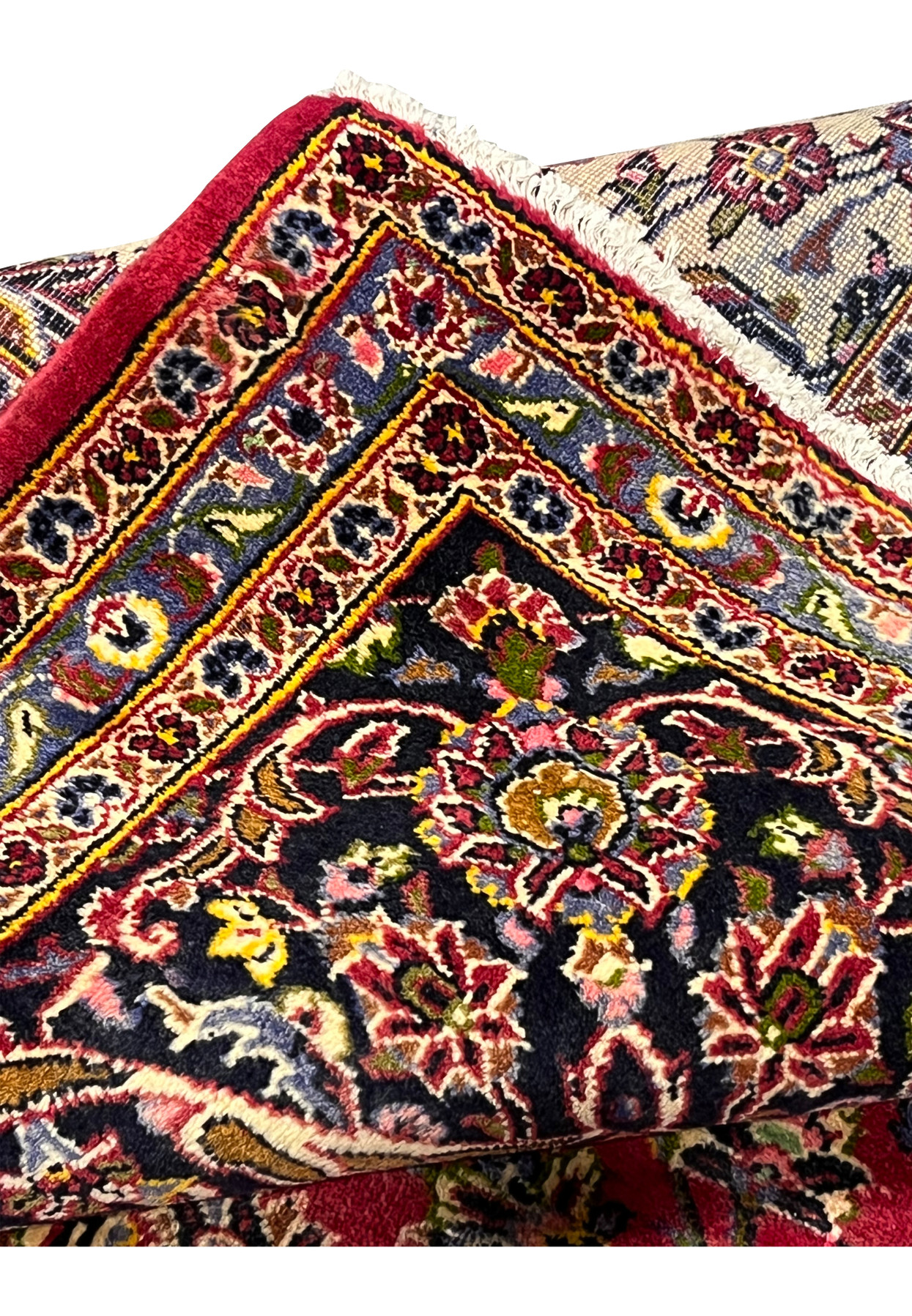 Folded edge of the Kashan revealing the navy border and even hand-knotting on the reverse.