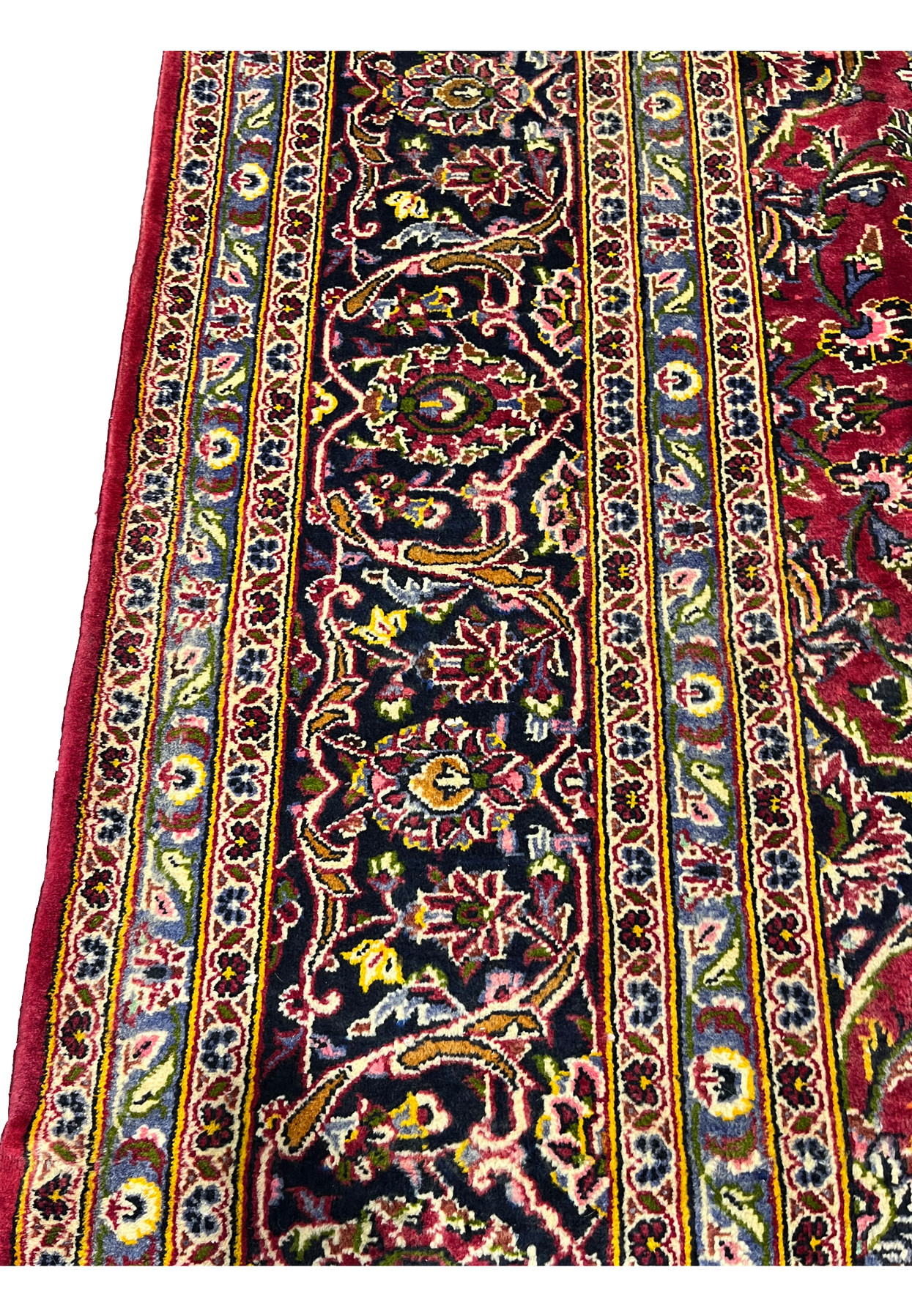 Close-up of the navy border with rose, gold, and green florals on this vintage Persian Kashan.
