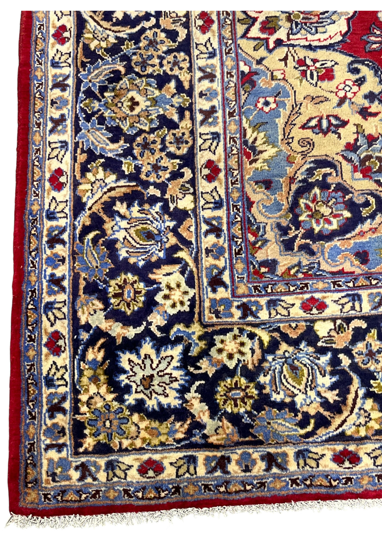 Corner of the Najafabad showing the layered ivory and navy border against the red field.