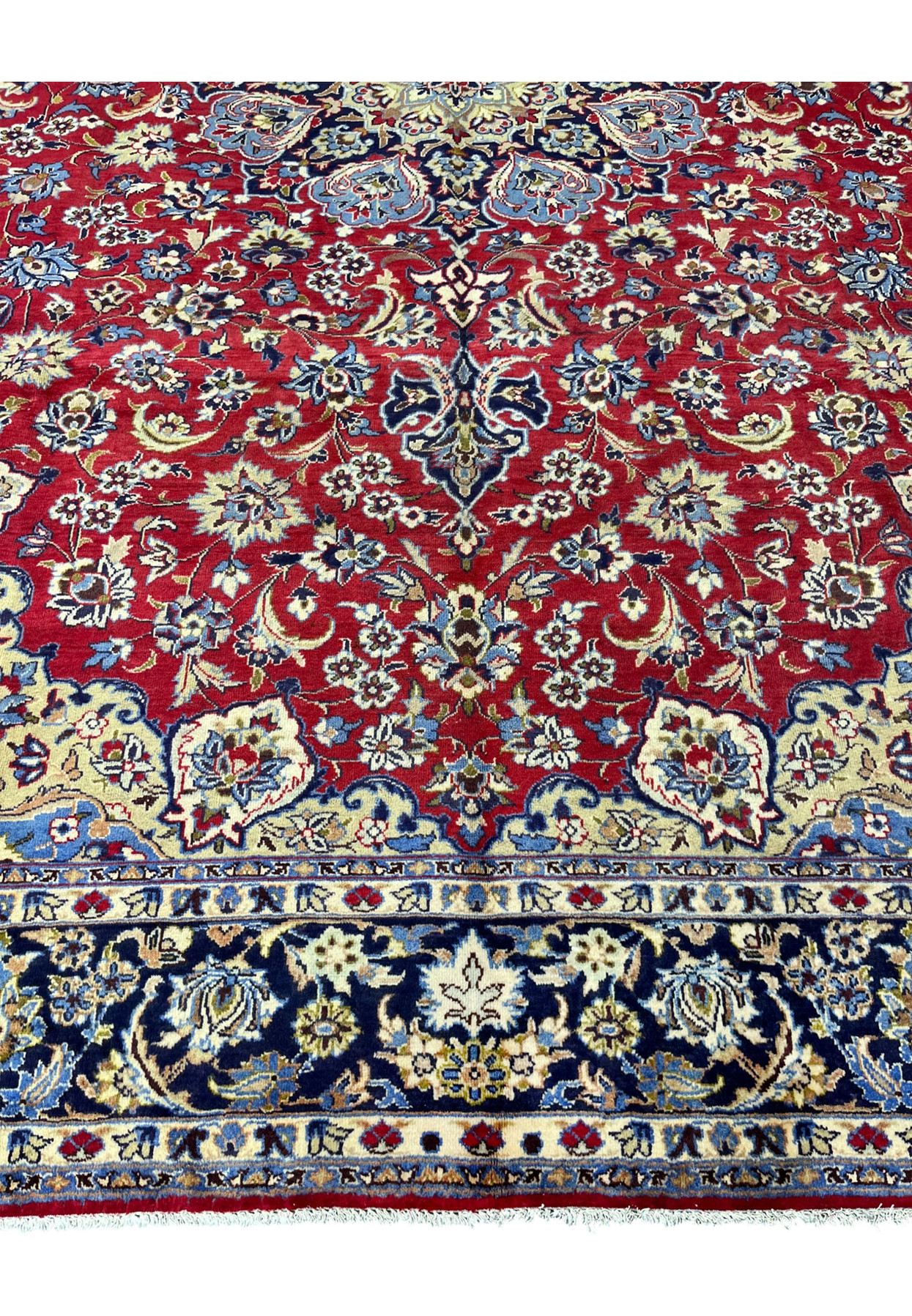 Crimson field densely woven with palmettes, rosettes, and curving vines below the central medallion.