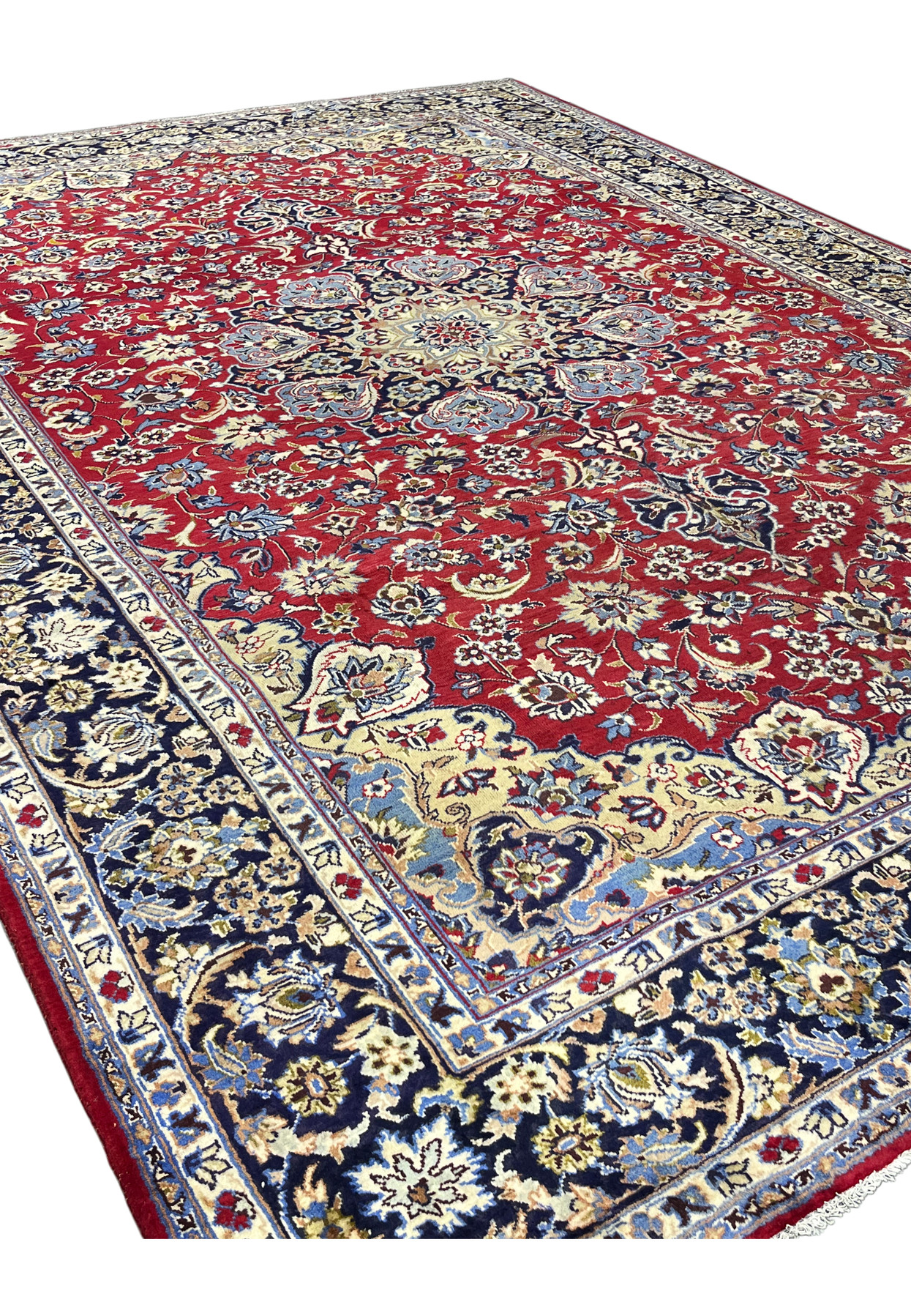 9x13 Najafabad rug seen on the diagonal, red ground scattered with blossoms under a navy frame.