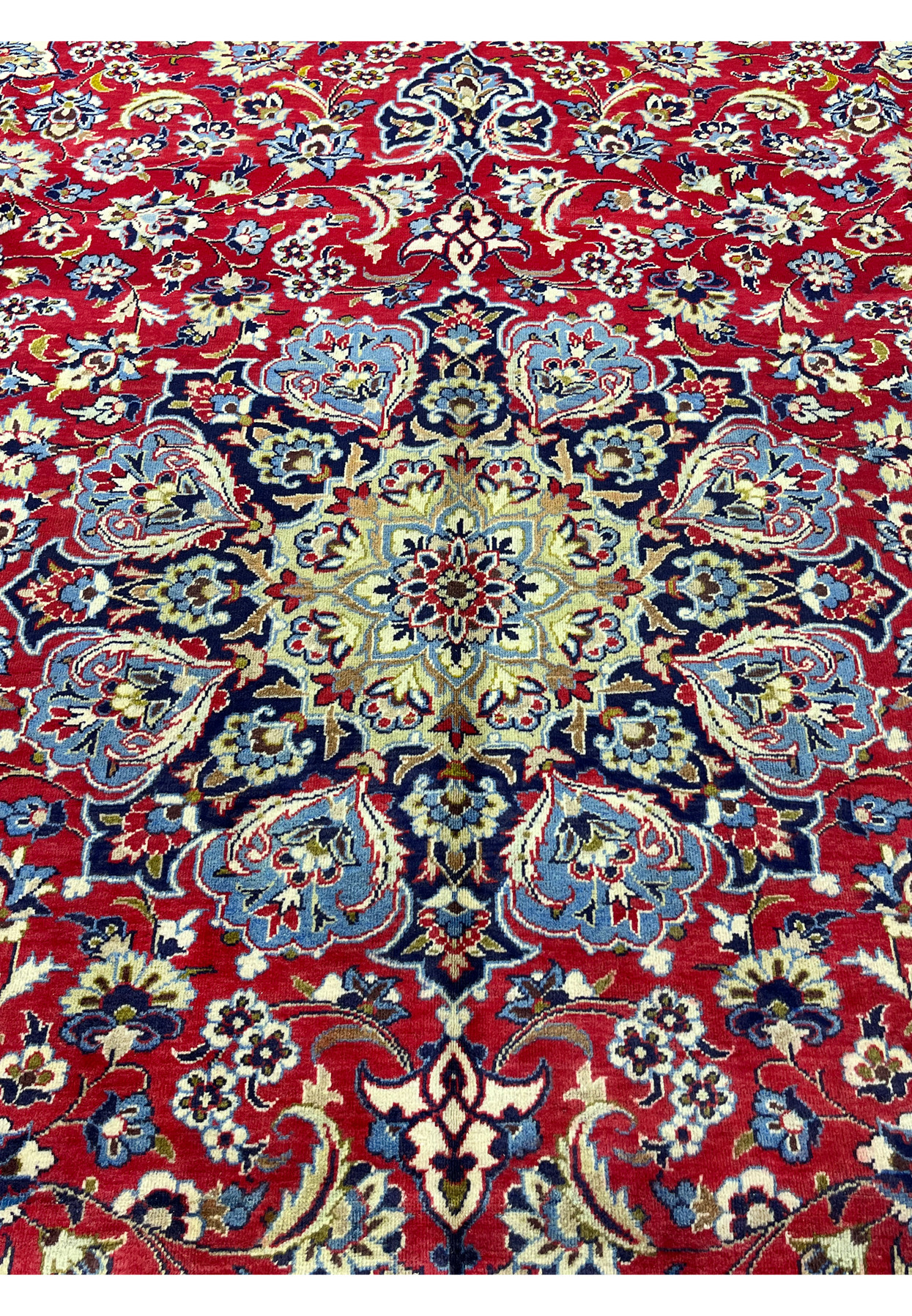 Ivory and navy center medallion surrounded by sky blue palmettes and red floral tracery.