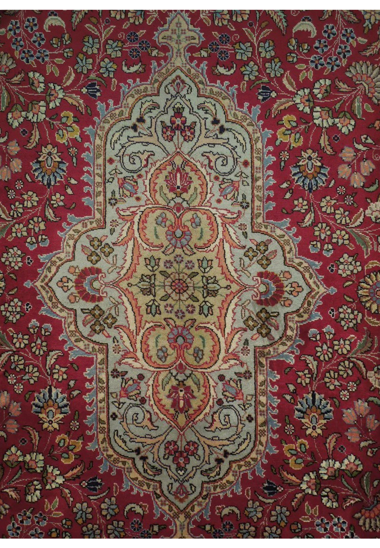 Scalloped light blue and beige medallion detail surrounded by blossoms on deep red ground