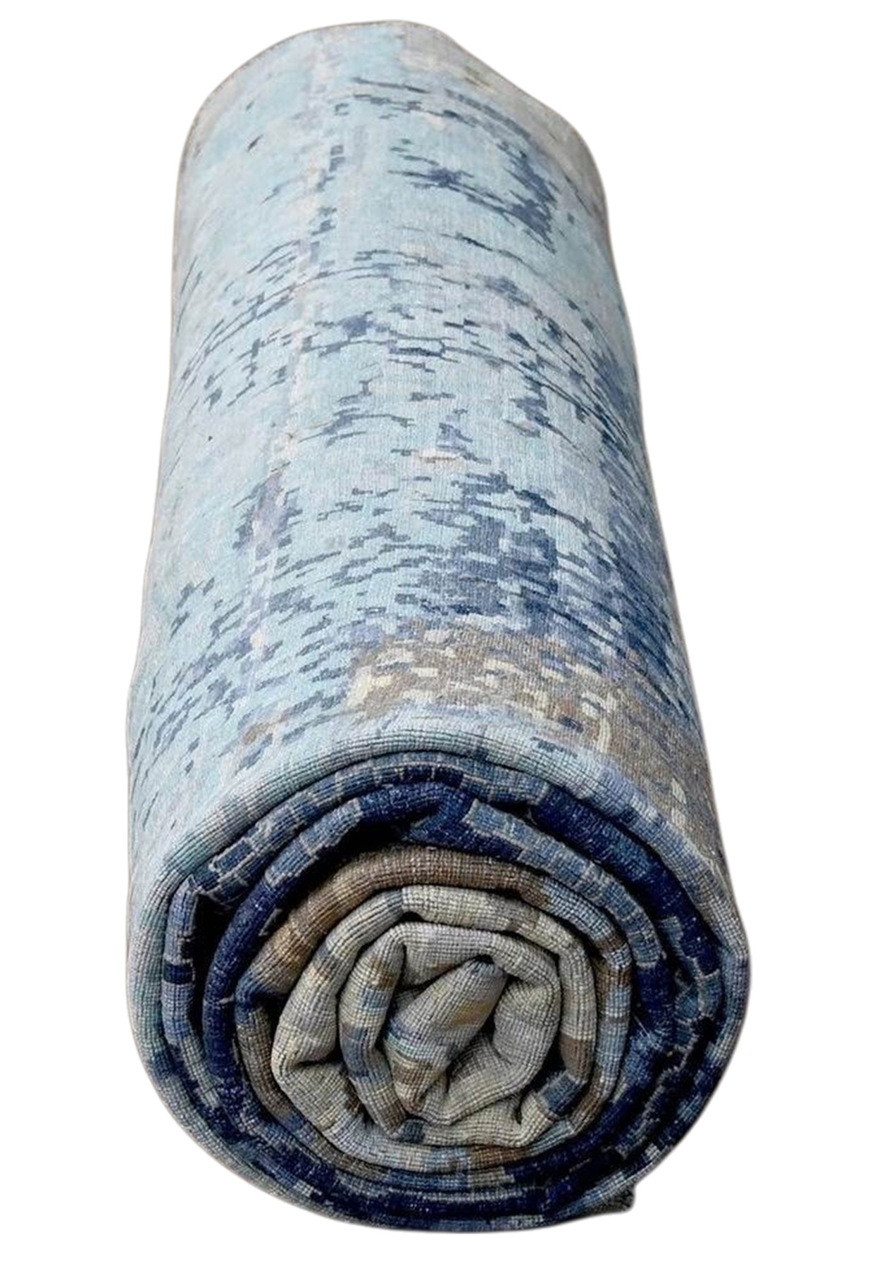 Rolled oversize blue abstract rug showing pale turquoise end and layered color transitions from light aqua to deep navy blue