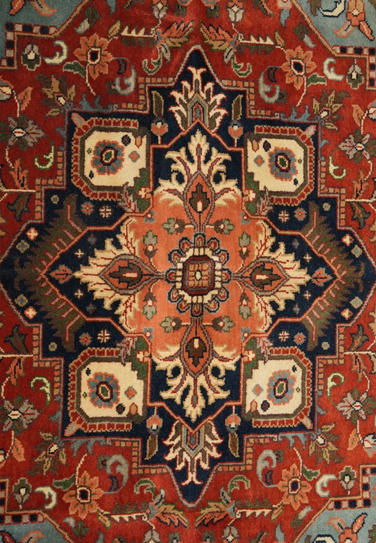 Layered geometric star medallion in navy, ivory and coral centered on brick red ground