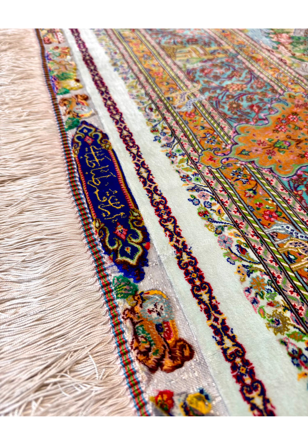 Close view of the Iran Qum Tabatabai signature woven in golden silk thread