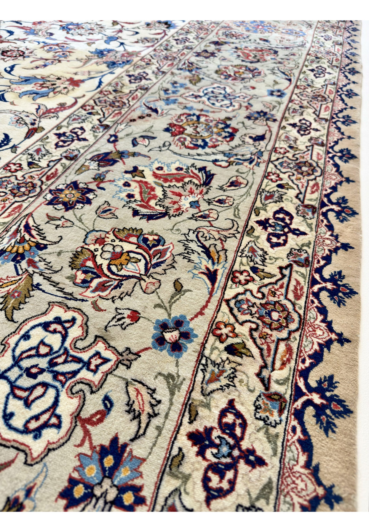 Close view of the border showing red, navy and gold flowerheads knotted in fine kork wool