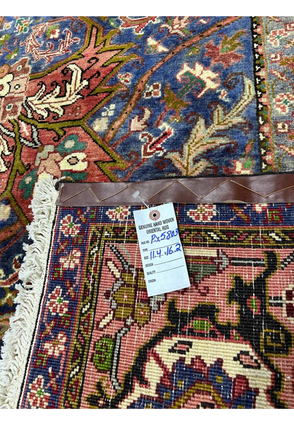 Reverse of the Heriz with dealer tag, cotton foundation and tight even knotting visible