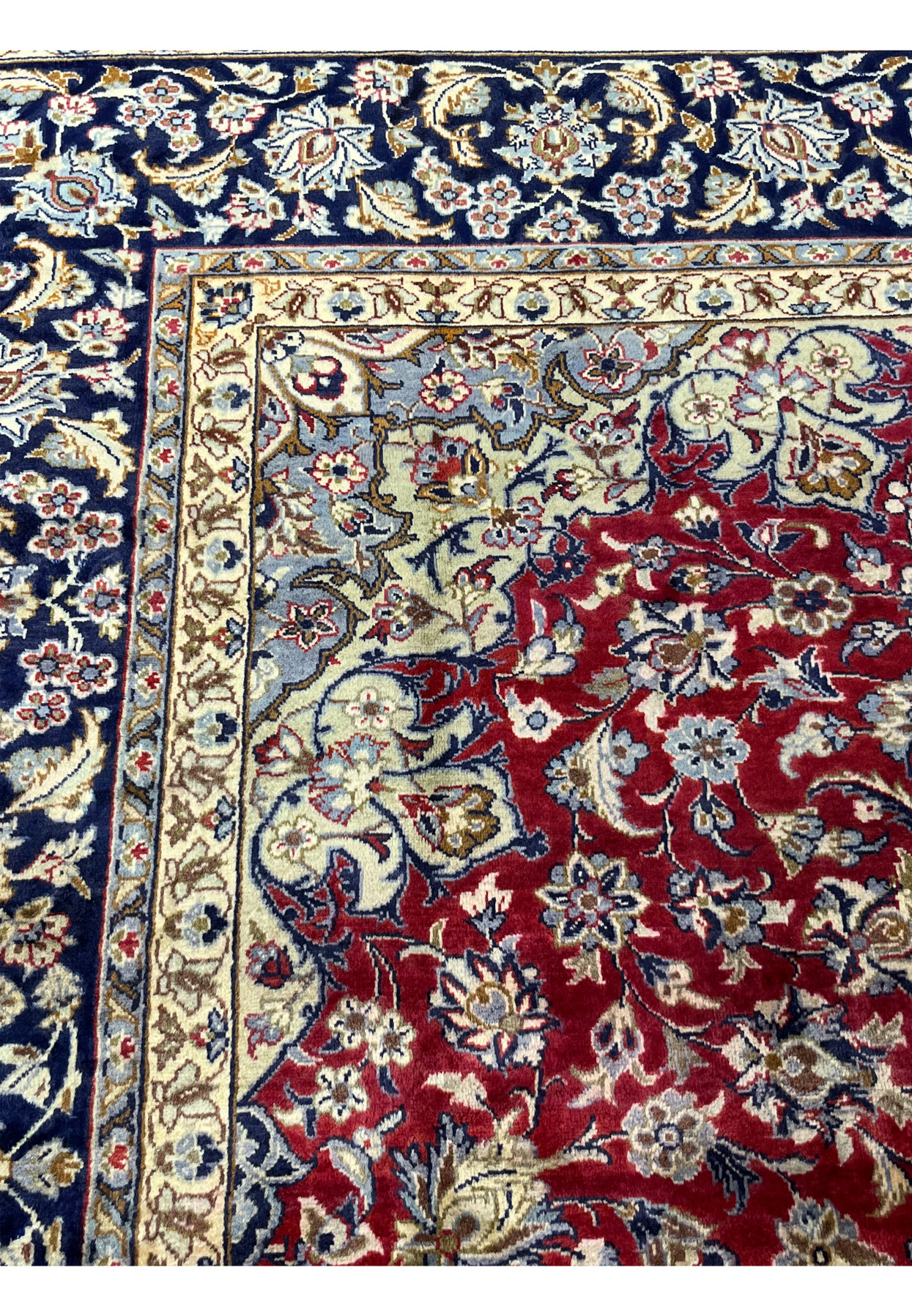 Pale blue spandrel and ivory guard stripe framing the corner of this Isfahan rug