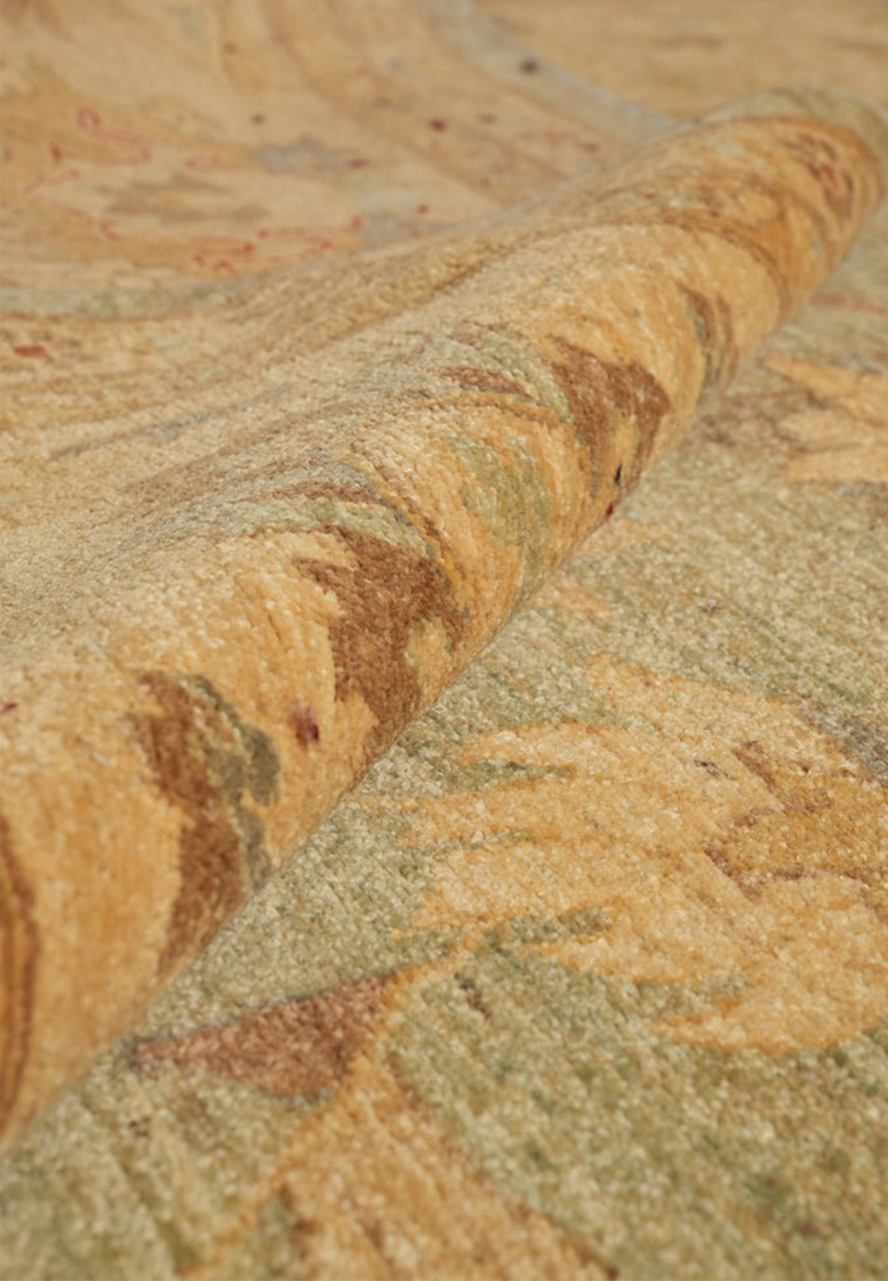 Rolled edge of the oversize Chobi rug revealing dense wool pile and hand-knotted foundation