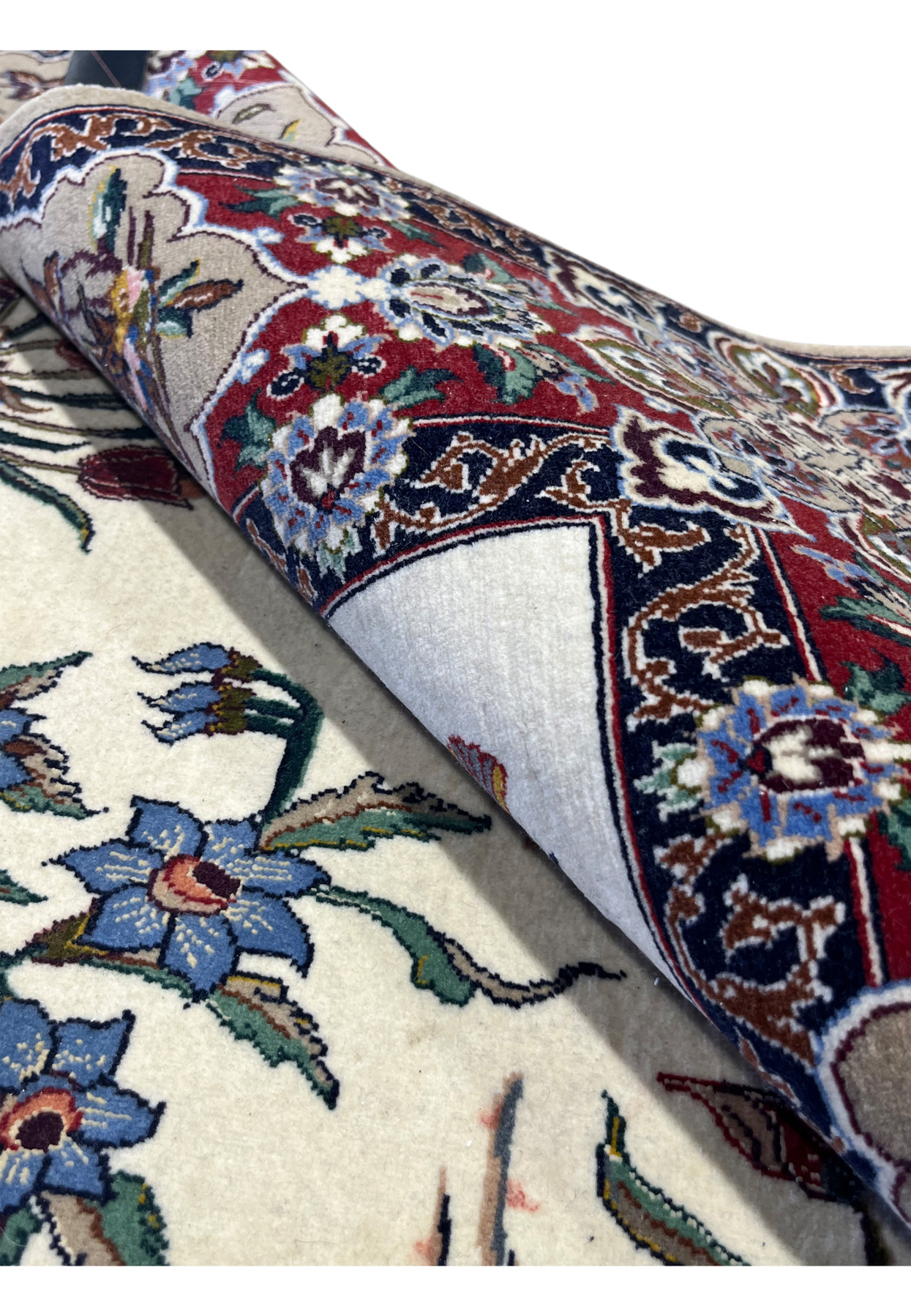 4x6 Persian Isfahan rug folded back to show pile depth and the red main border