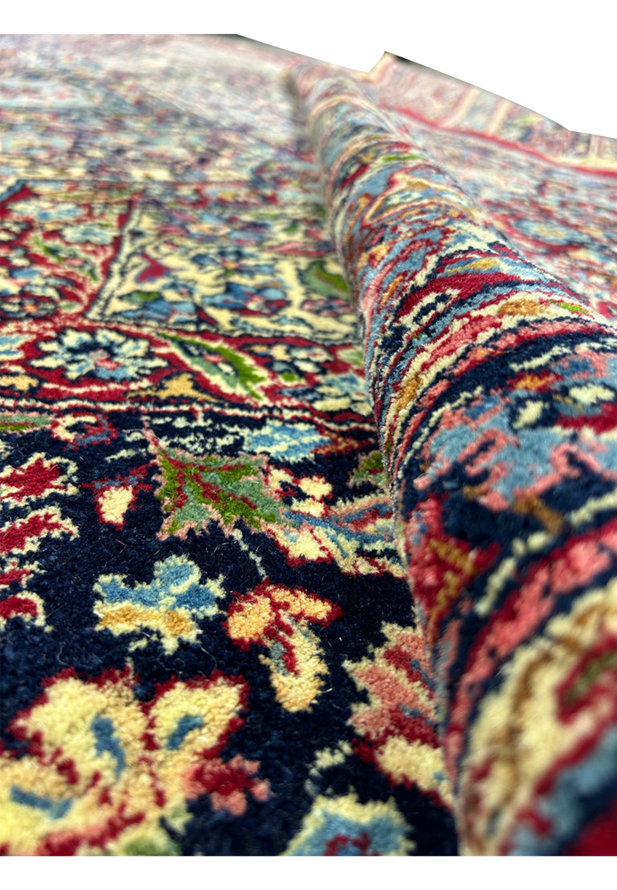 18x18 square Kerman rug rolled back to reveal pile height and border colors
